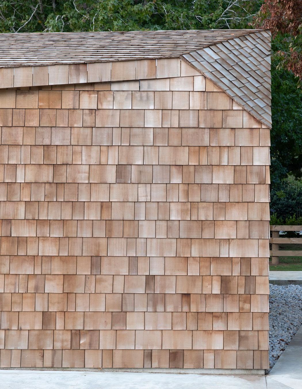 Cedar shingles add texture and warmth to the sharp sculptural form of the garage.