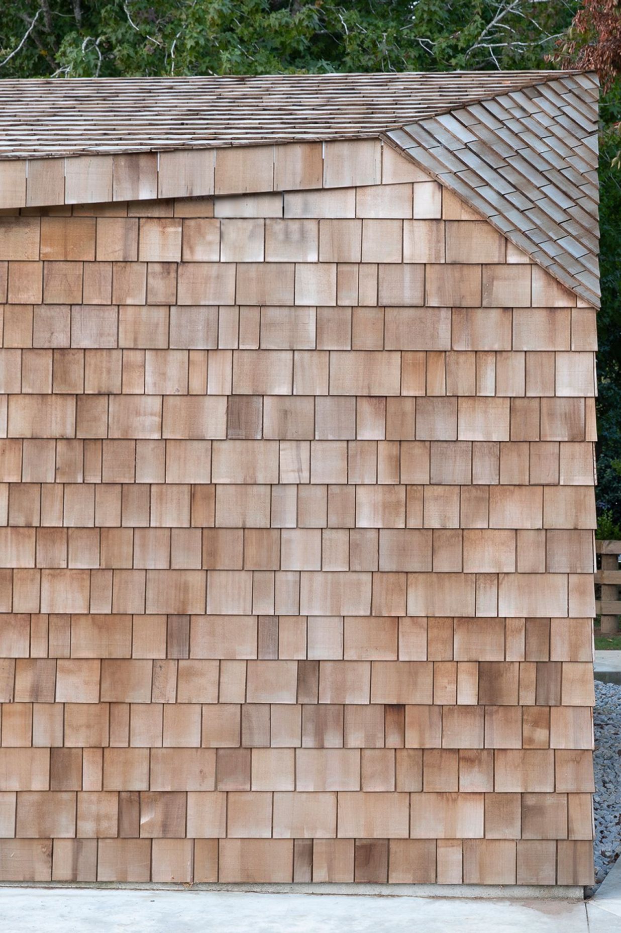 Cedar shingles add texture and warmth to the sharp sculptural form of the garage.