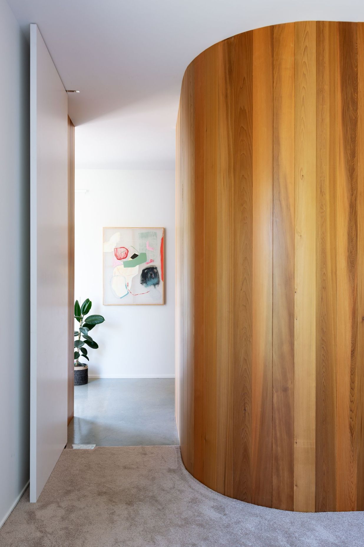 A combination of warm timber and a curved wall adds a lighter feel to the linear lines..
