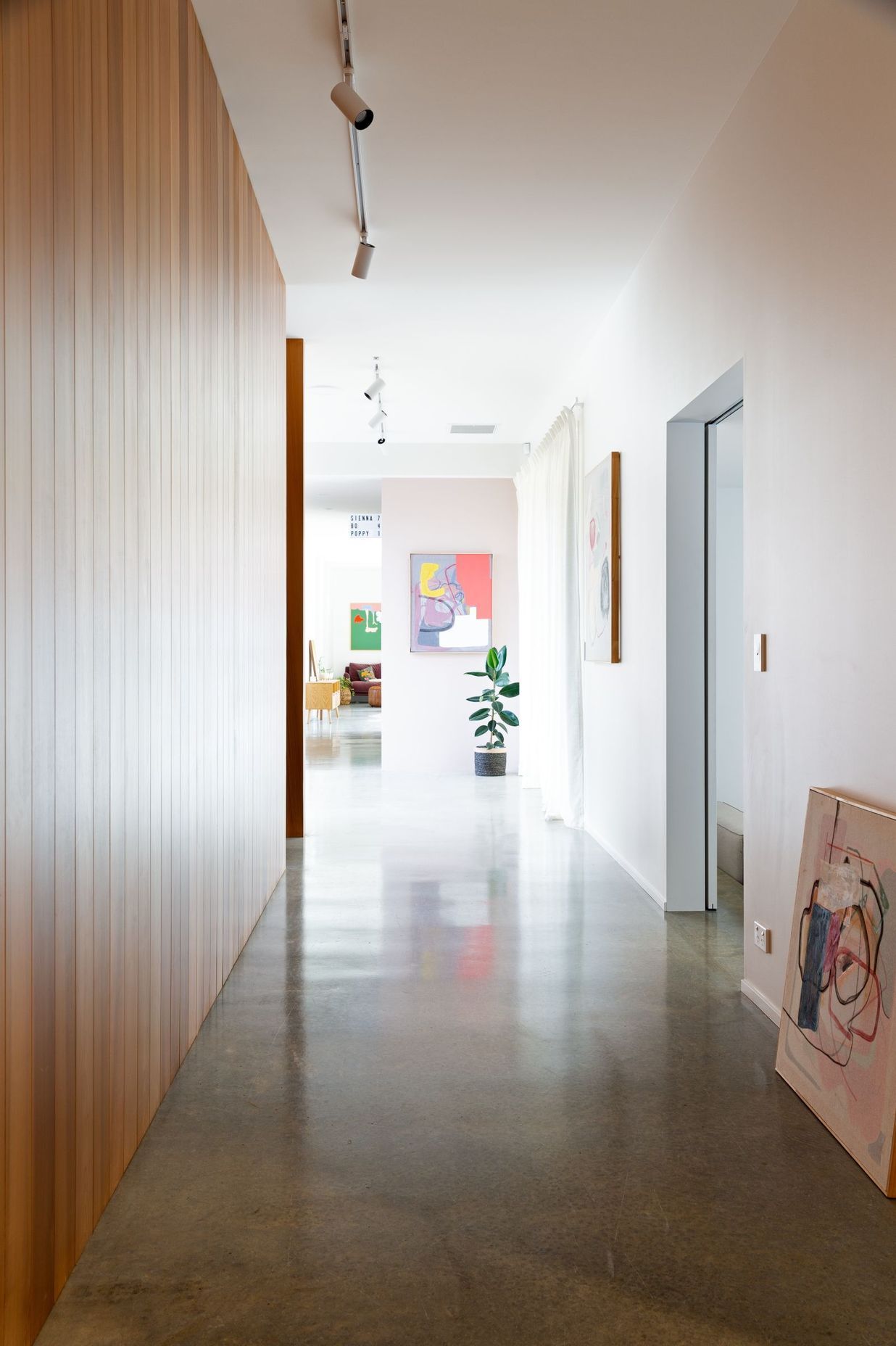 The gallery-like hallway showcases the owners' artworks.