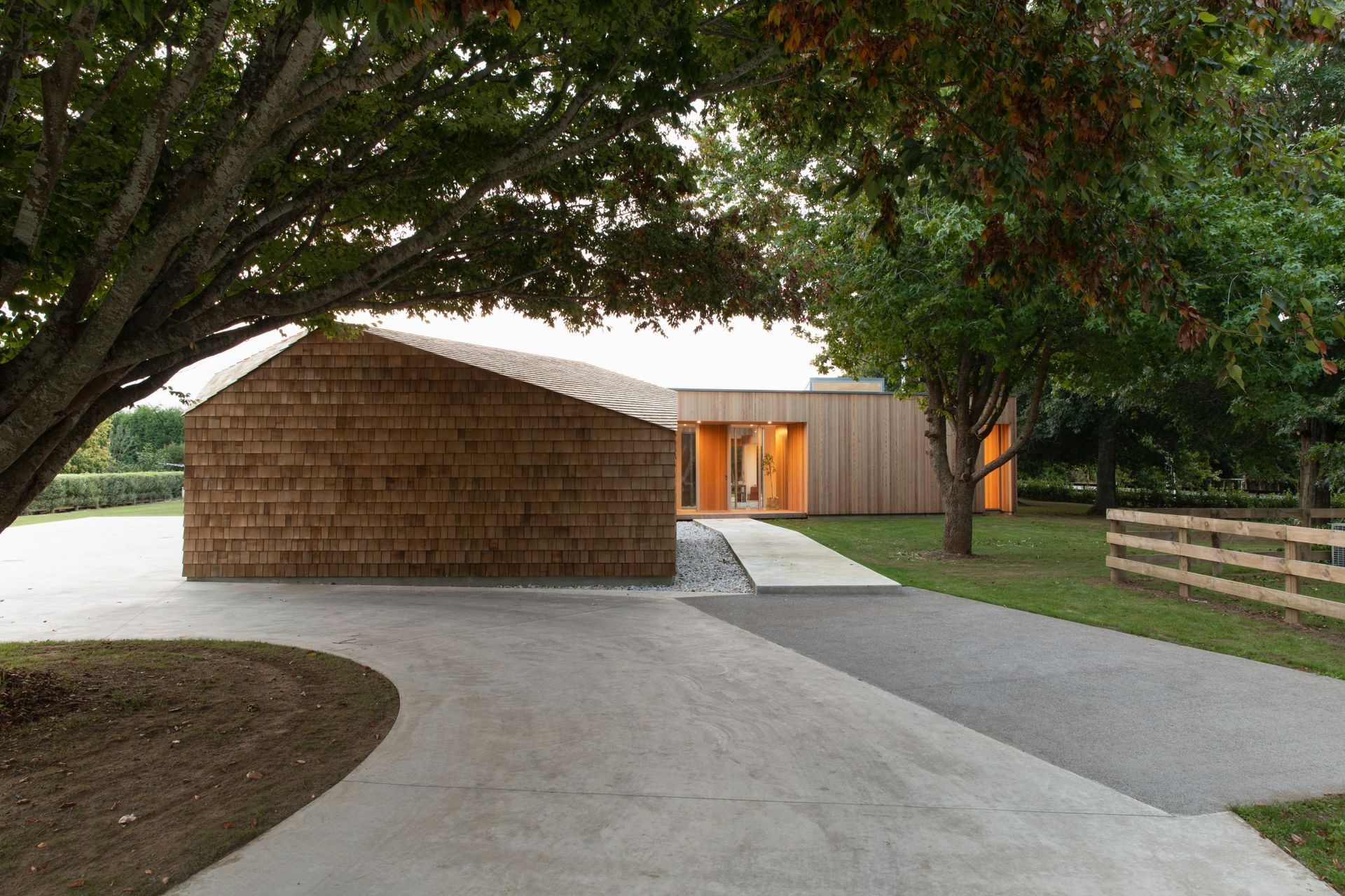 Plum, cherry, cedar and a golden elm tree line the driveway up to Shibui House, which is made up of three interconnected boxes cloaked in cedar.
