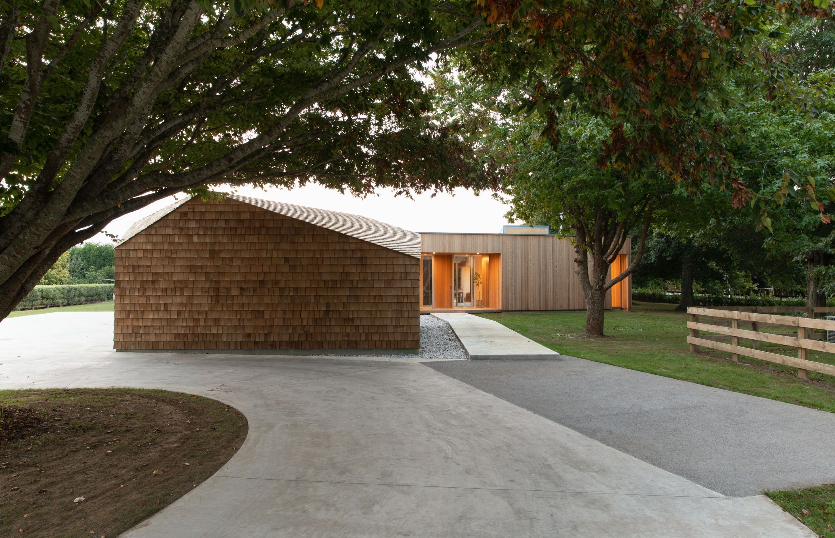 Plum, cherry, cedar and a golden elm tree line the driveway up to Shibui House, which is made up of three interconnected boxes cloaked in cedar.