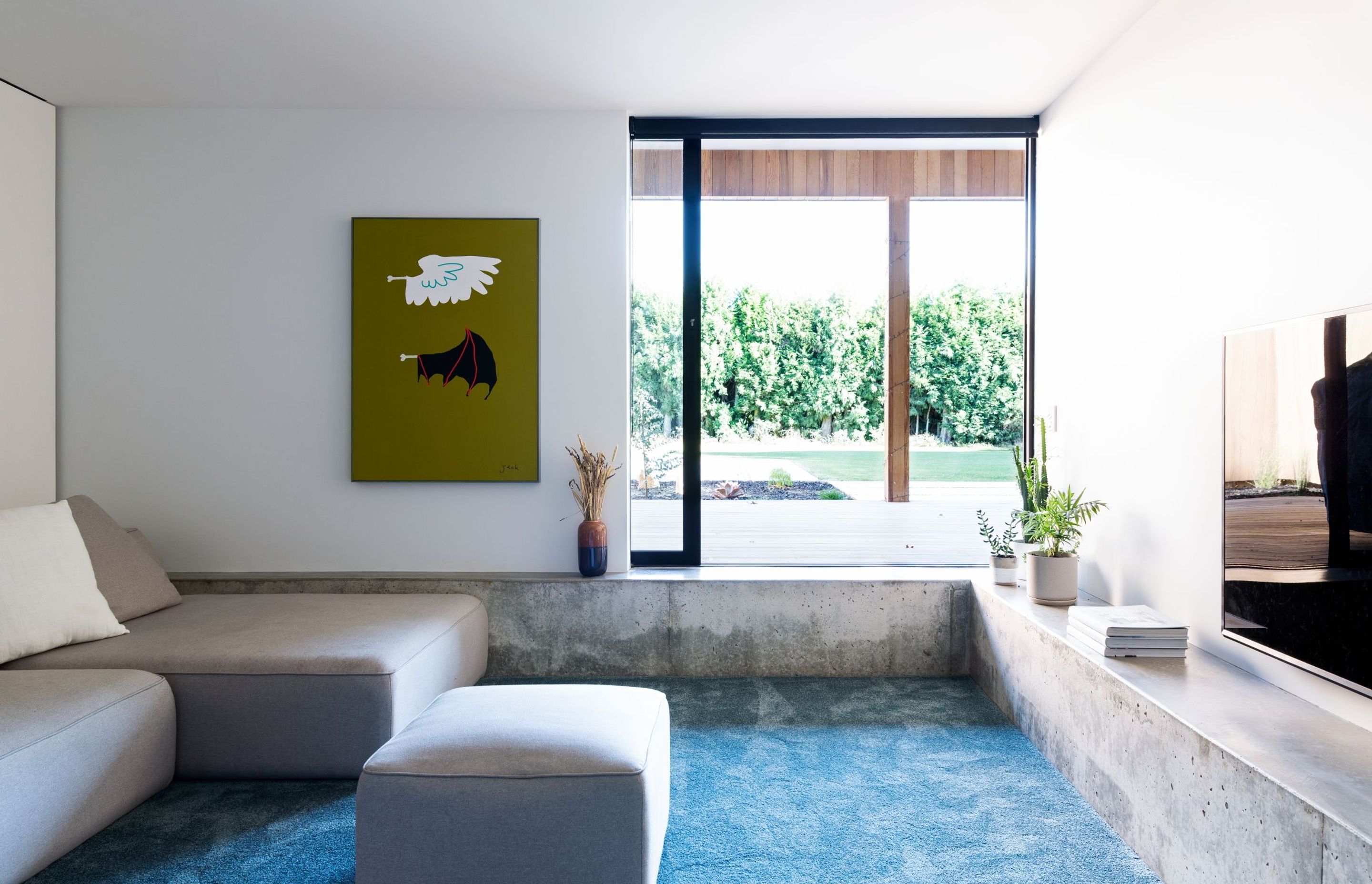 The sunken lounge features built-in concrete seating, exposing some of the structure of the home.
