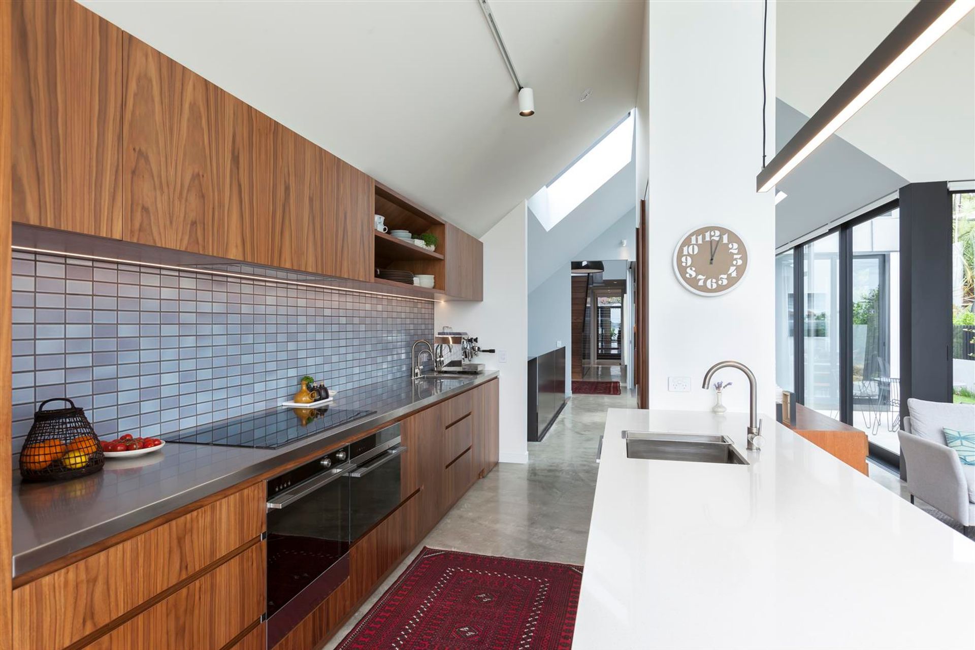 The internal material palette has been pared back, as per the client's wishes, to incorporate polished concrete, walnut timber and steel plate, offset by crisp white and muted tones.