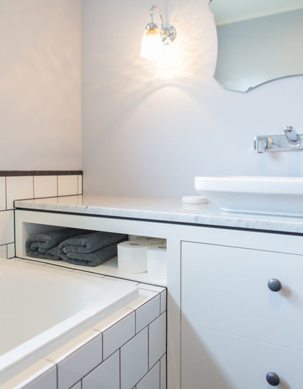 Generous vanity bench space also creates extra storage in this small bathroom.