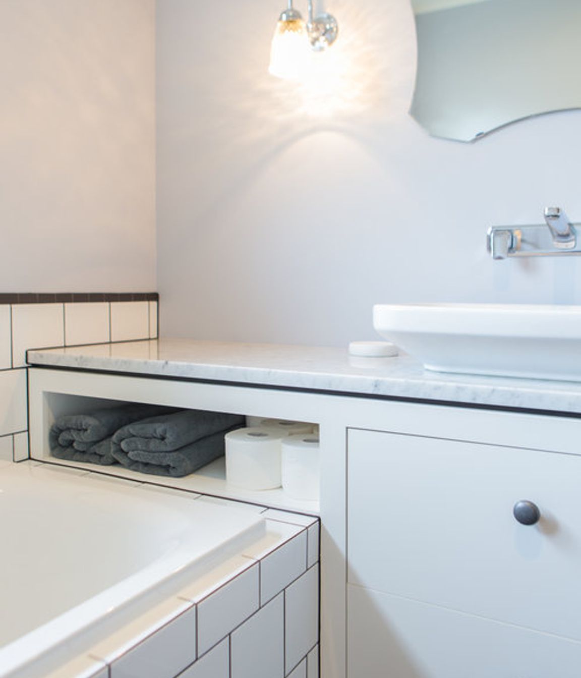 Generous vanity bench space also creates extra storage in this small bathroom.