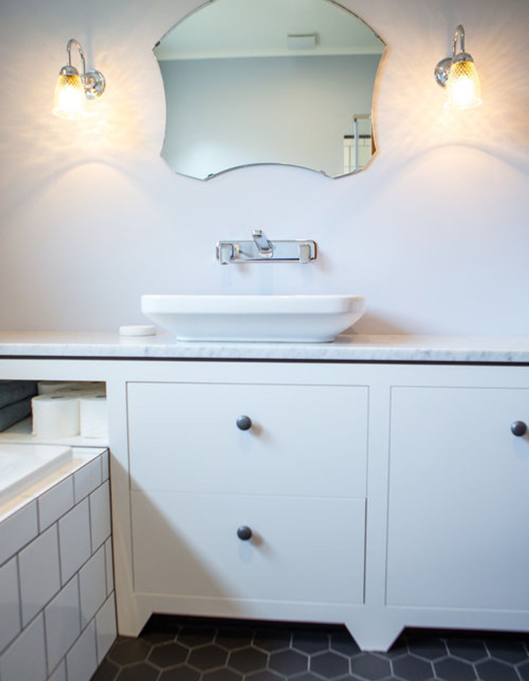 A cute foot on the vanity and tiled floor add to the quirky vintage finds.