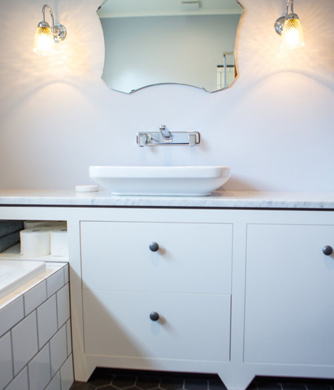 A cute foot on the vanity and tiled floor add to the quirky vintage finds.