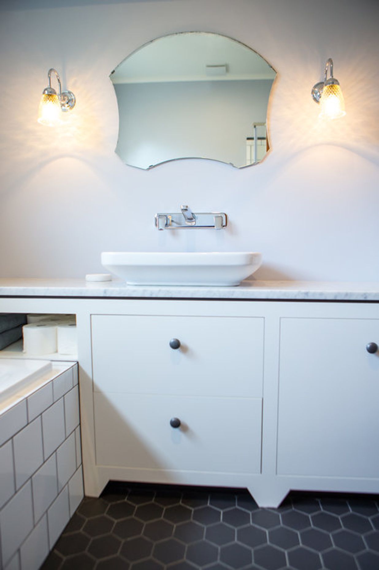 A cute foot on the vanity and tiled floor add to the quirky vintage finds.