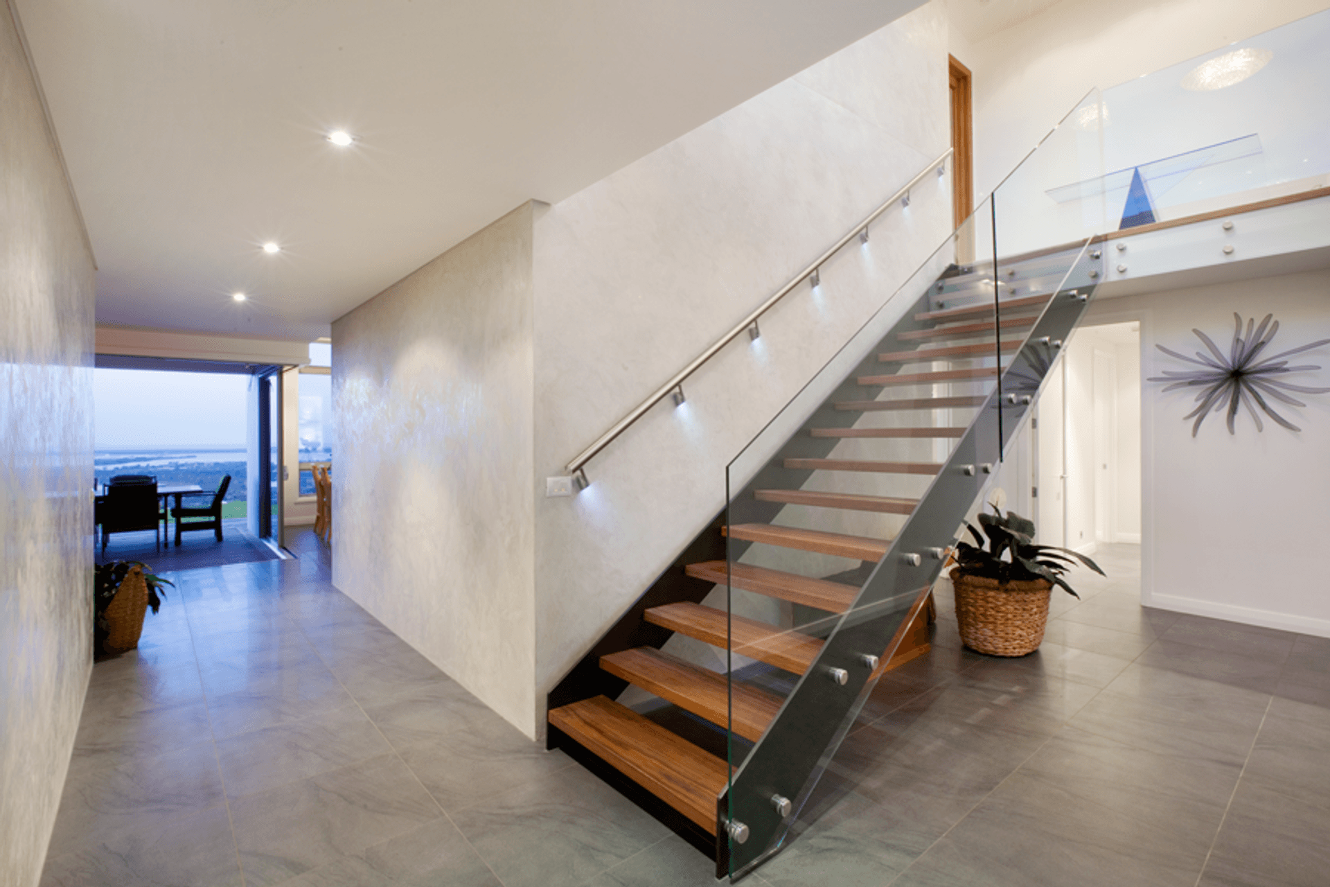 A striking floating stairwell with timber treads in the entry provides access to the upstairs bedroom areas.
