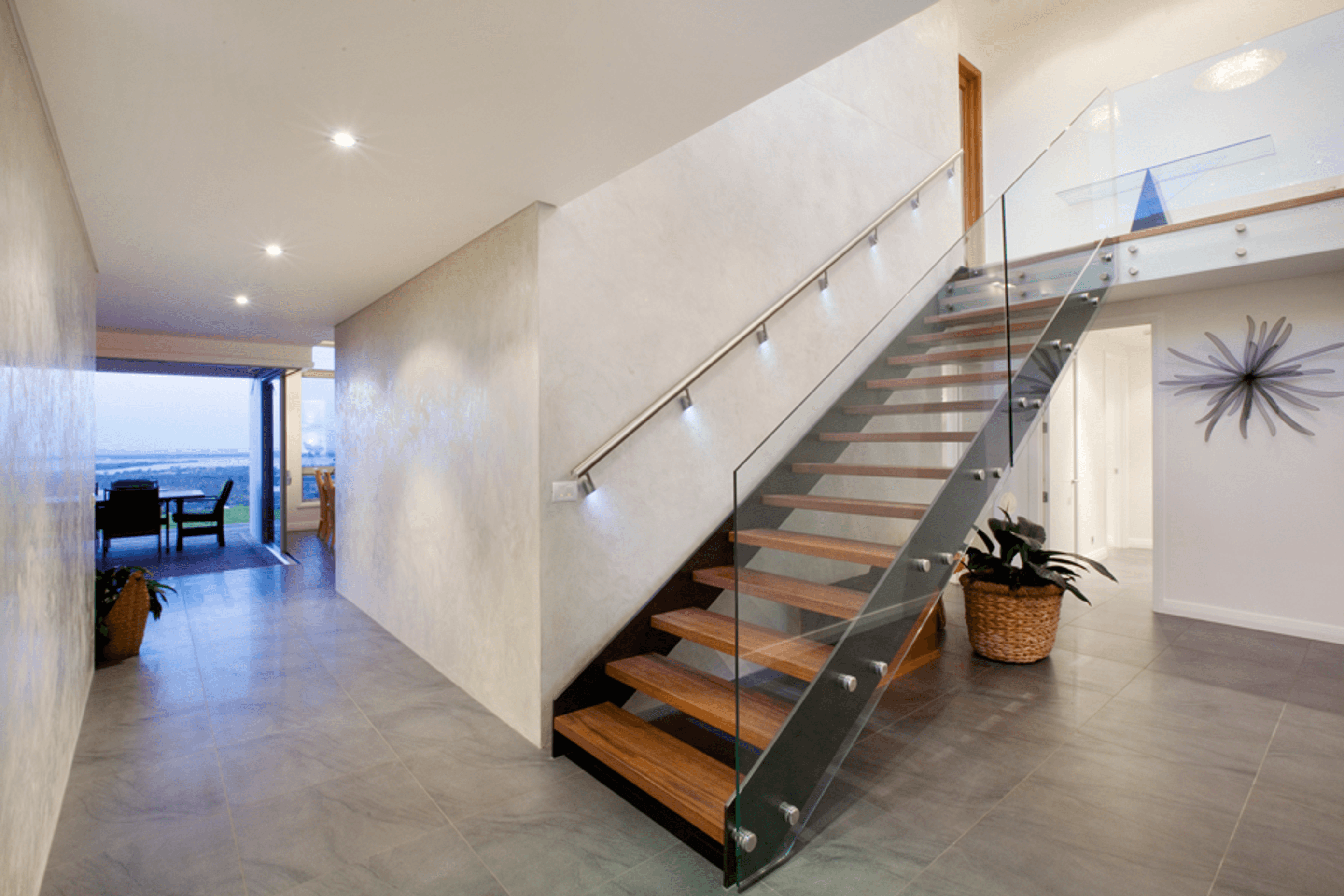 A striking floating stairwell with timber treads in the entry provides access to the upstairs bedroom areas.