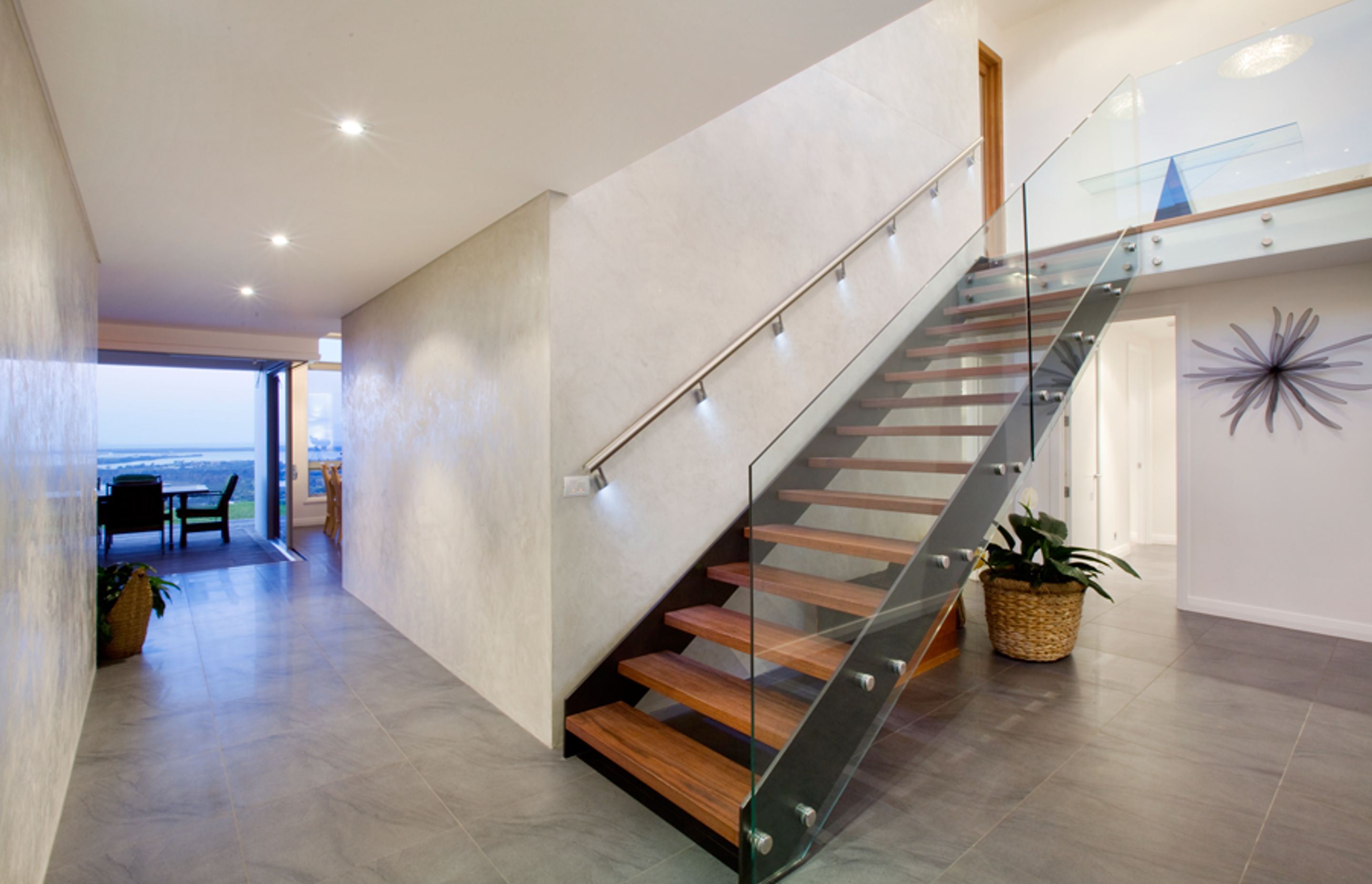 A striking floating stairwell with timber treads in the entry provides access to the upstairs bedroom areas.