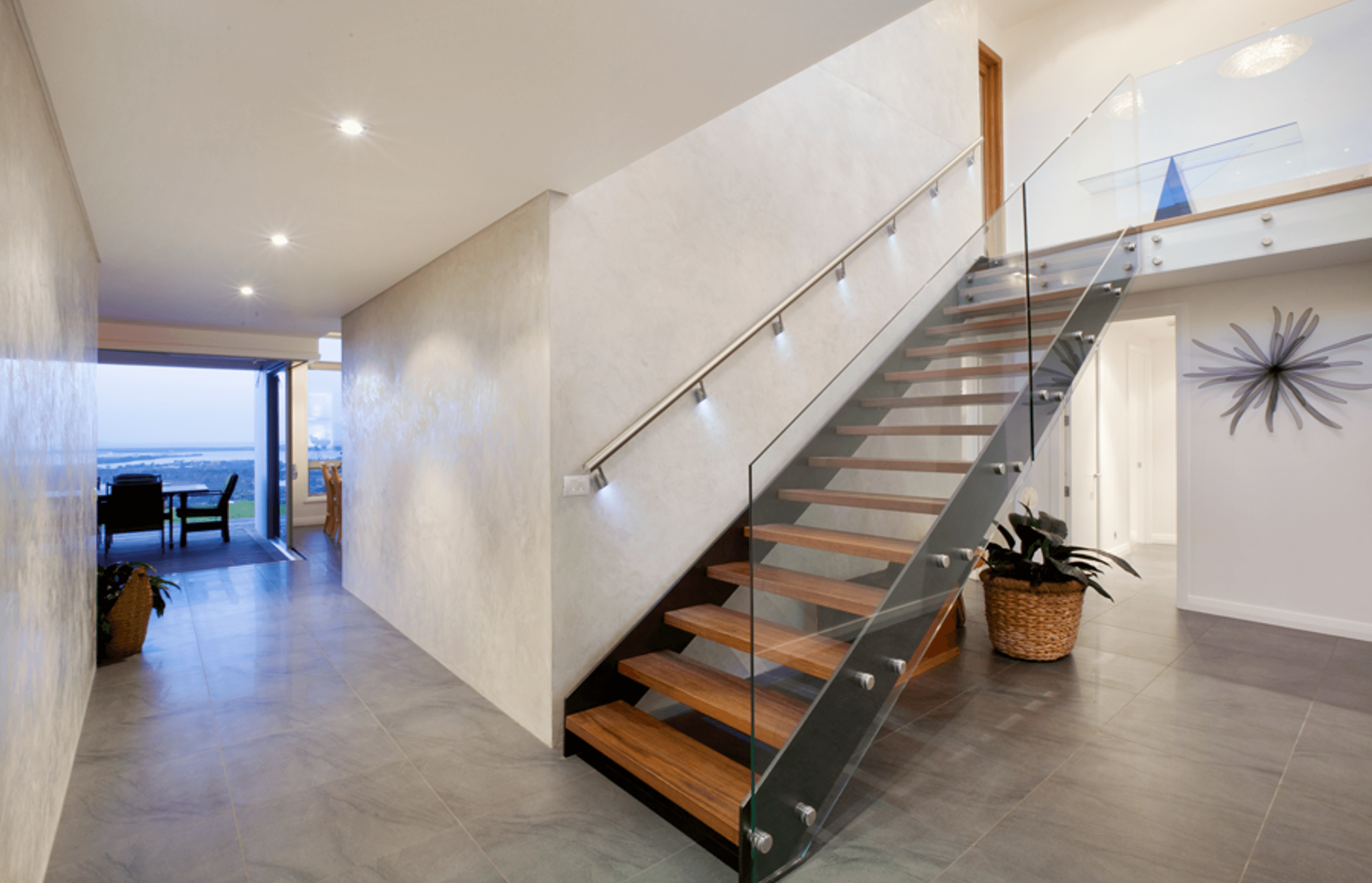 A striking floating stairwell with timber treads in the entry provides access to the upstairs bedroom areas.