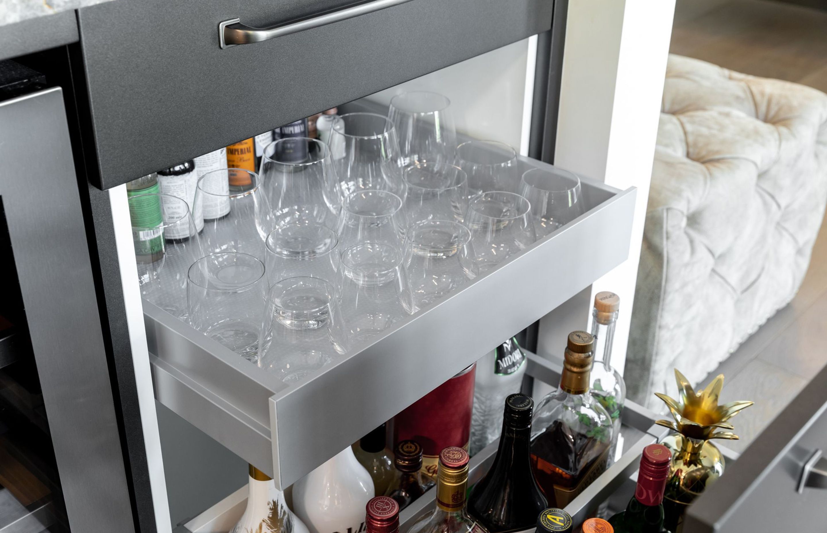 Clever storage features were integrated throughout the kitchen. Spirits, mixers and glasses are easily accessible beneath the Bar with full-extension Grass NovaPro drawer runners by Häfele.