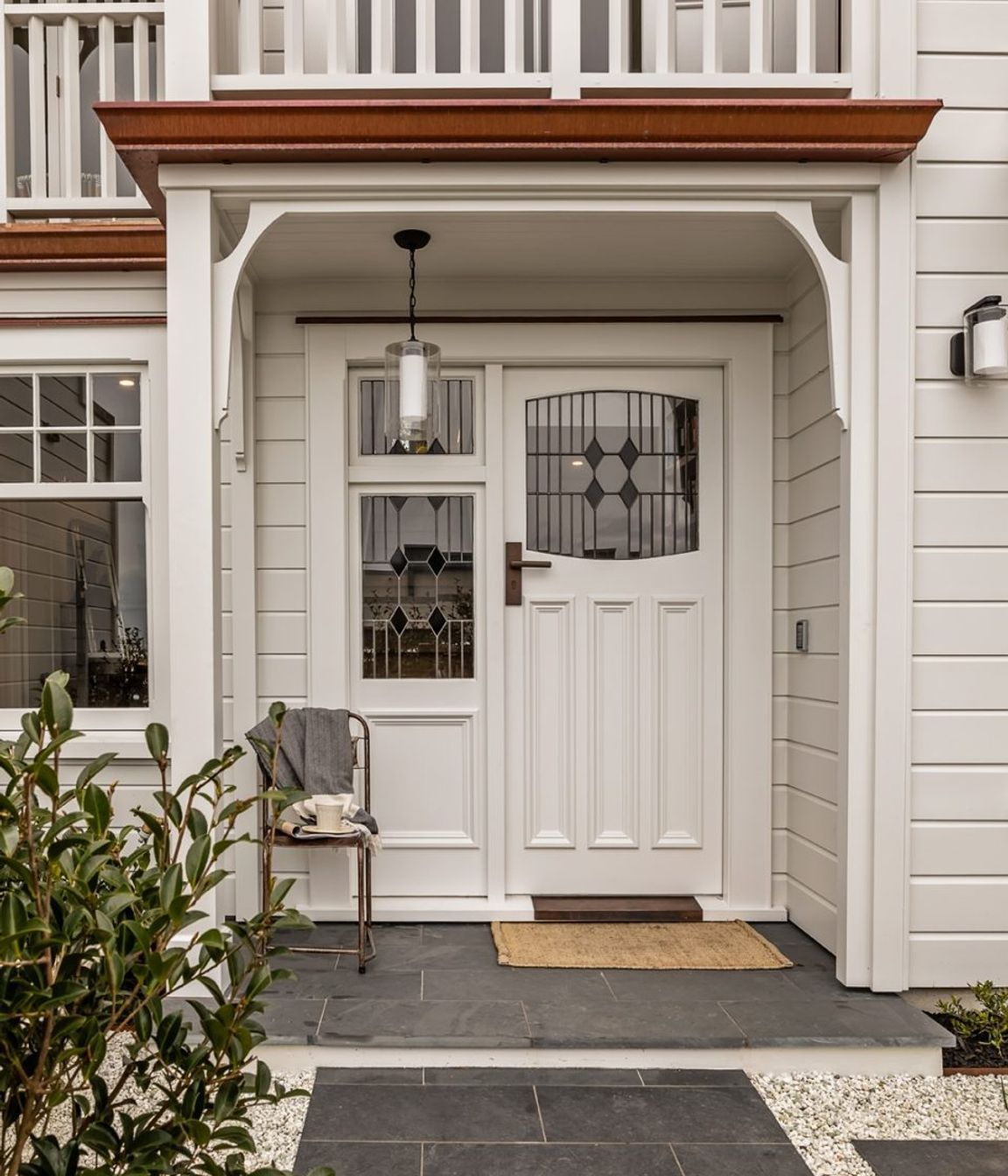 The front entrance is tiled in basalt and features stained glass windows to match the original house.