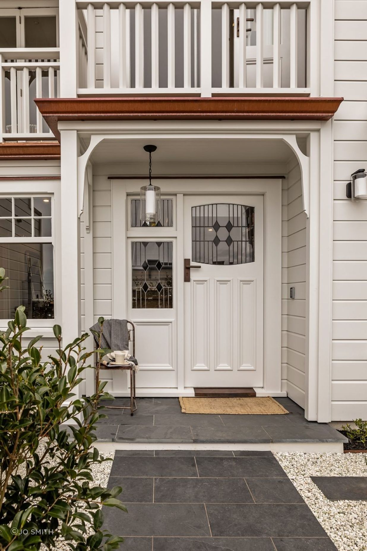 The front entrance is tiled in basalt and features stained glass windows to match the original house.