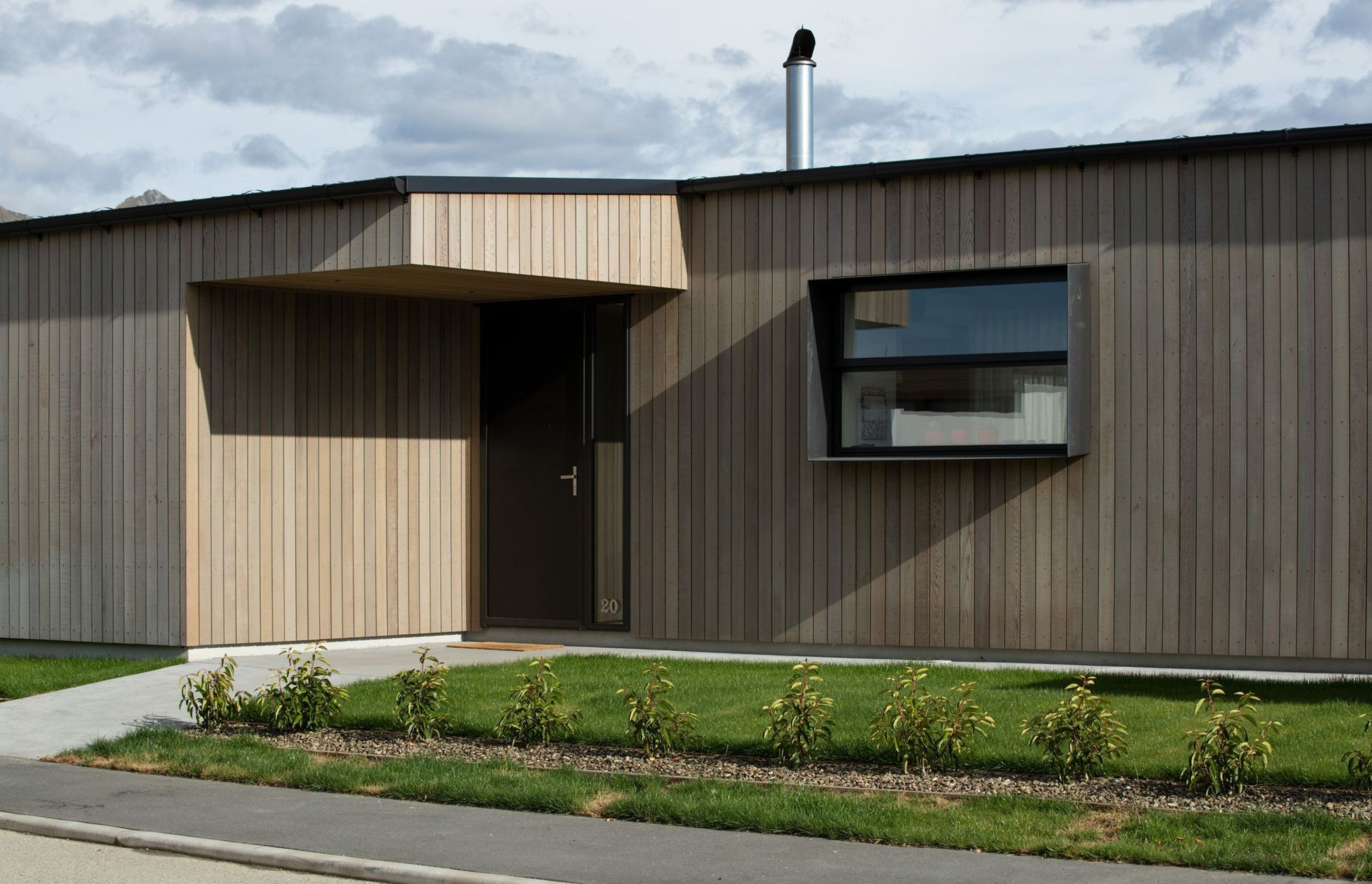 The timber cladding continues over this entrance, giving the home a seamless contemporary form.