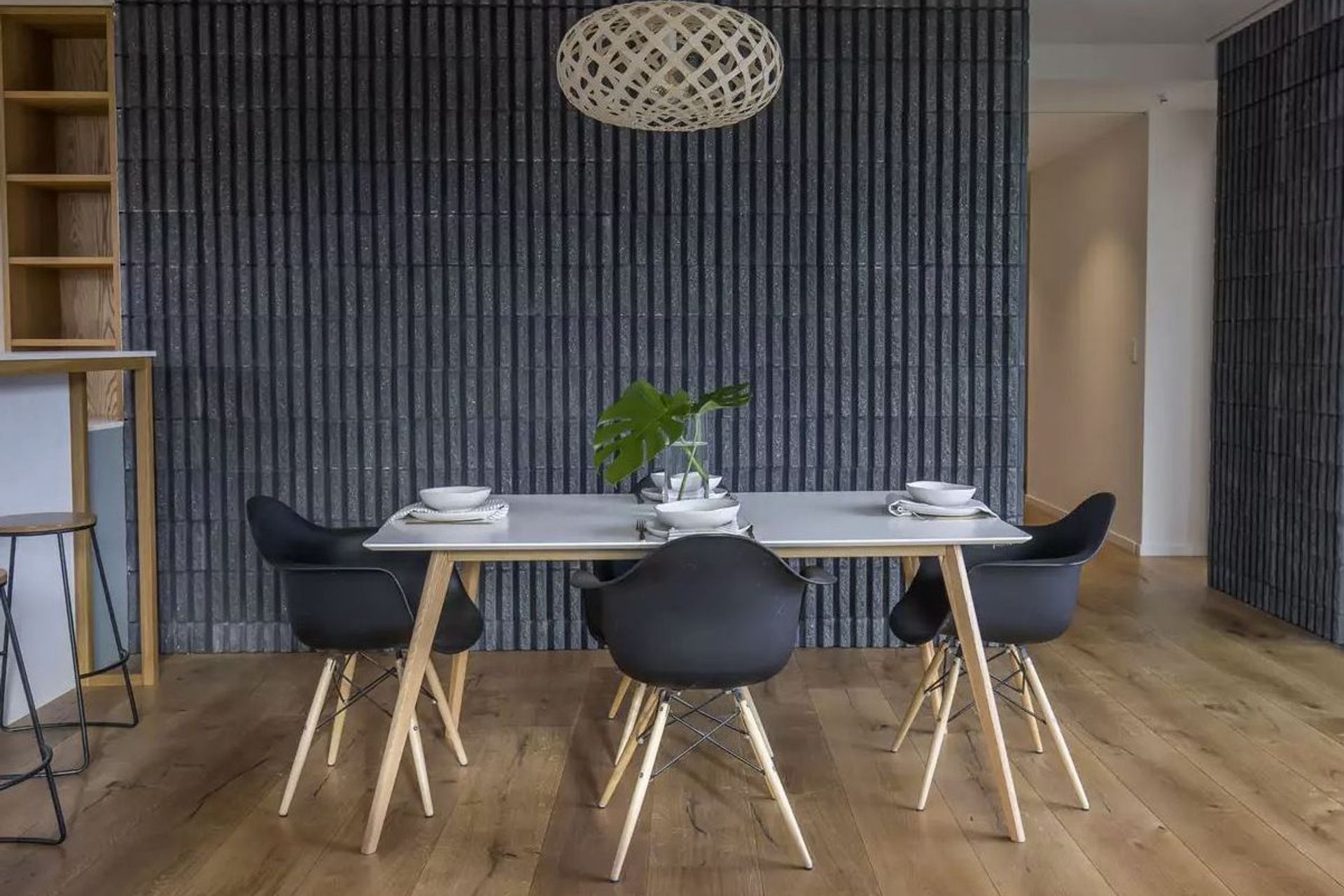 This dining room features oak flooring and a feature wall in charcoal-coloured, fluted-concrete blockwork.