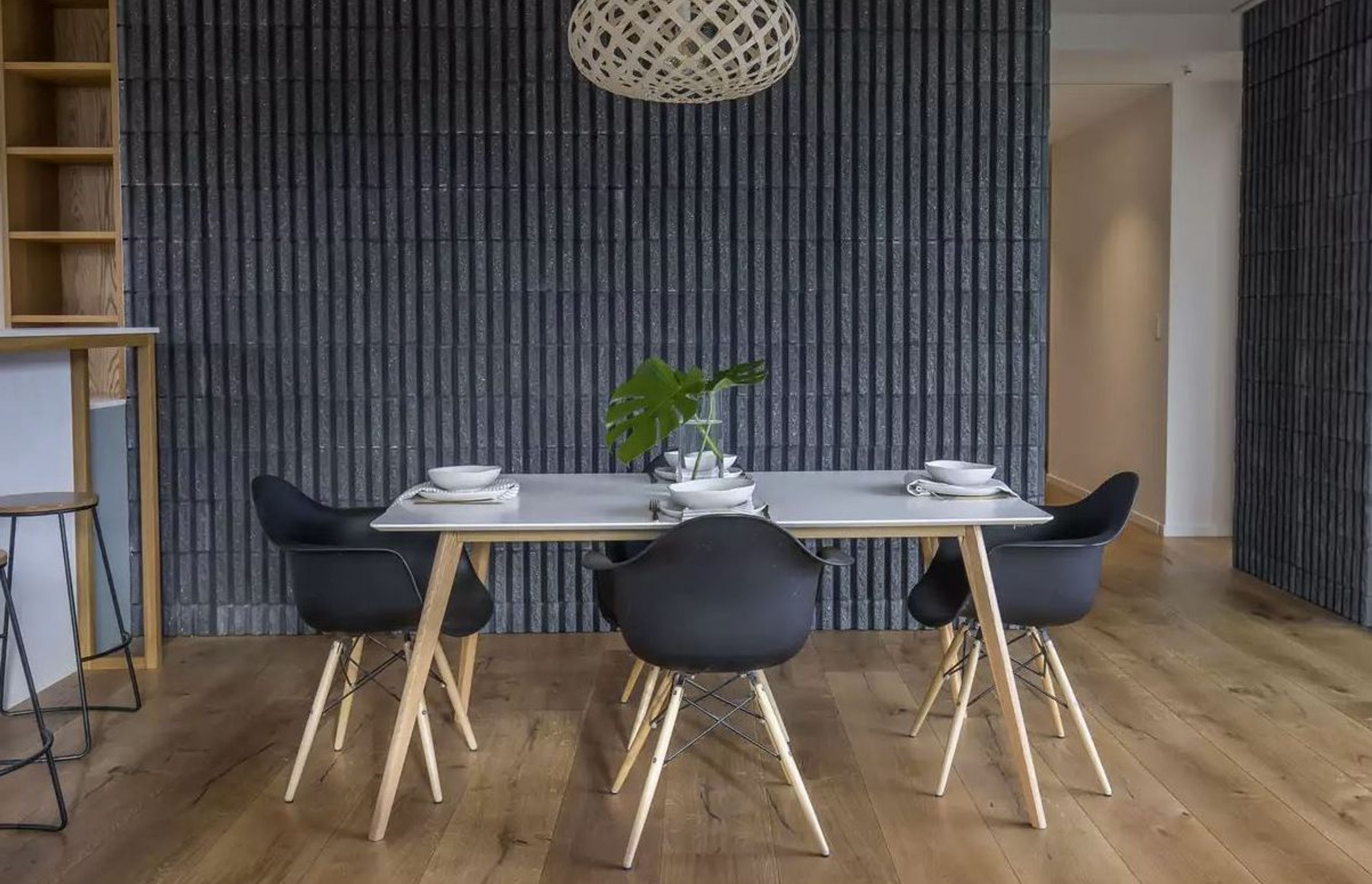 This dining room features oak flooring and a feature wall in charcoal-coloured, fluted-concrete blockwork.