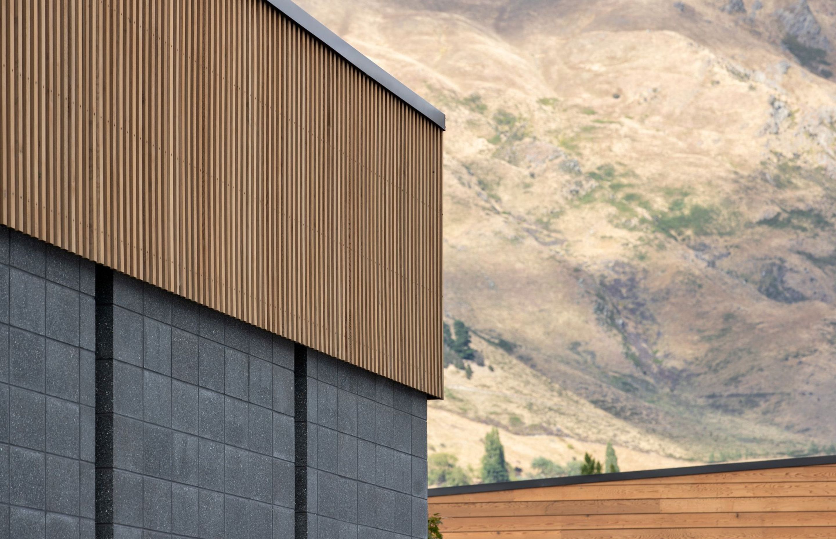 A material palette of timber and concrete complement the surrounding mountains.