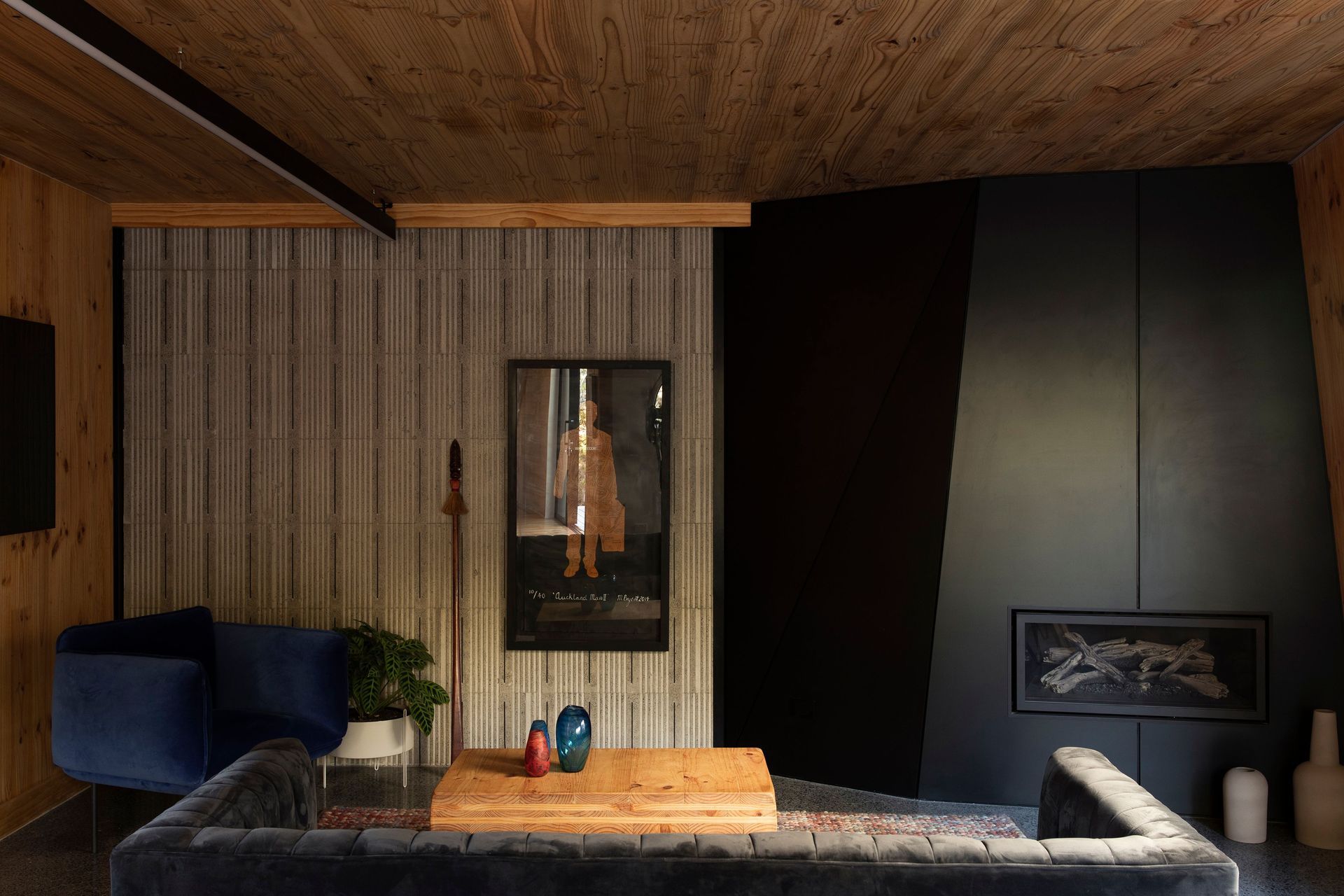 The lounge area has two feature walls, one faceted wall hosts the fireplace, while the concrete wall has a textural impression created by polystyrene formwork.