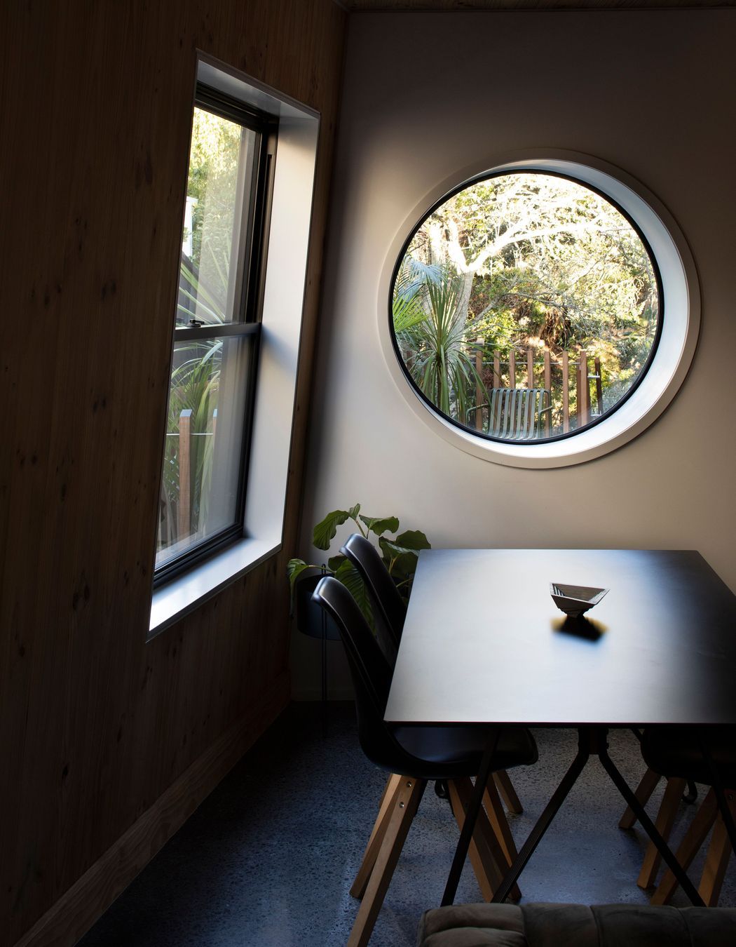 A port hole in the dining area looks out over the deck to the plum tree.
