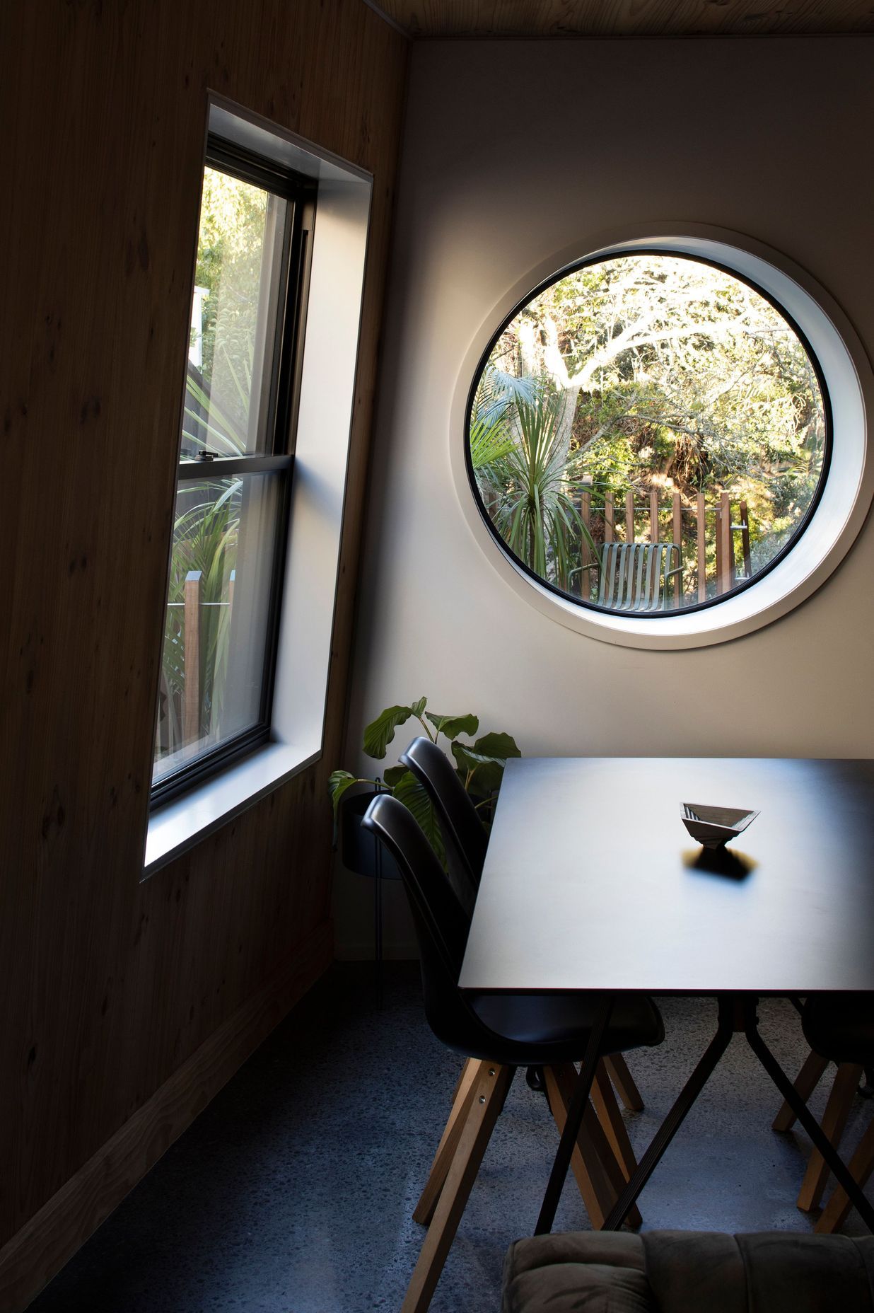 A port hole in the dining area looks out over the deck to the plum tree.
