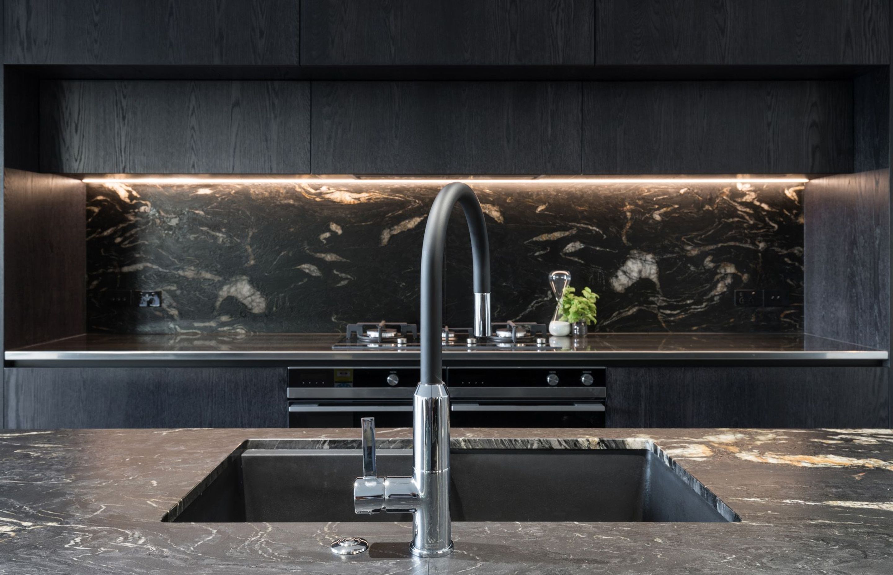 High-quality Italian granite surfaces and black timber cabinetry add beauty, texture and robustness to this busy kitchen.