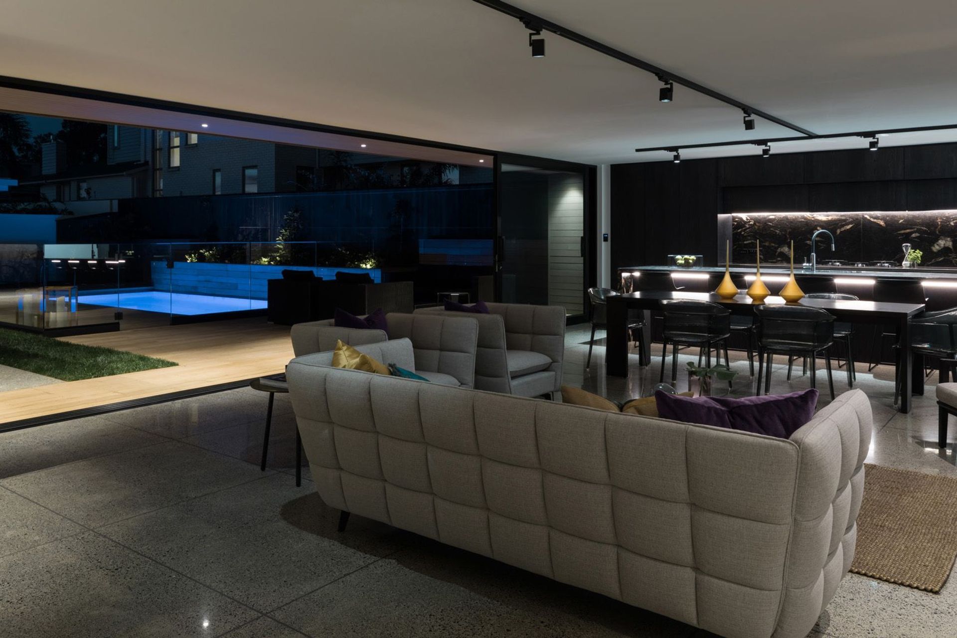 A large kitchen and living area is perfect for entertaining, with the added attraction of a swimming pool lit up like a light feature.