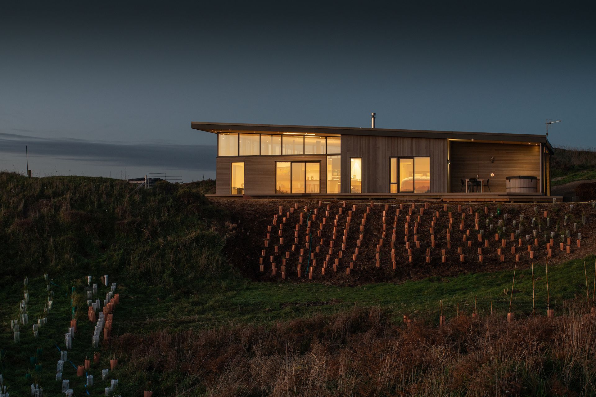 The house has been divided into three zones—a lofty, open-plan living area to the north, bedrooms in the middle and on the south-facing margin utilities and an intimate outdoor area with hot tub, the perfect spot for watching the sun set.