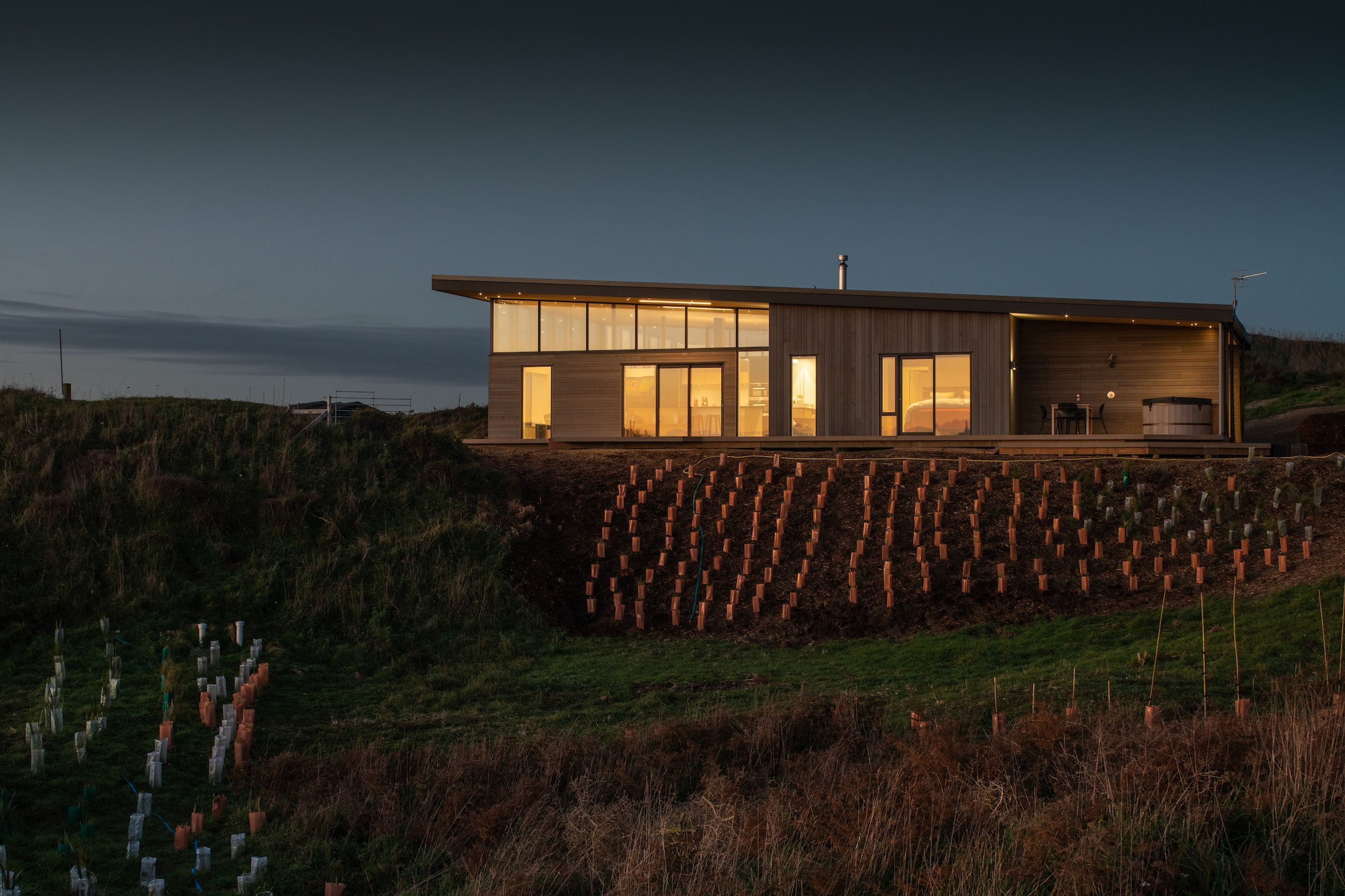 The house has been divided into three zones—a lofty, open-plan living area to the north, bedrooms in the middle and on the south-facing margin utilities and an intimate outdoor area with hot tub, the perfect spot for watching the sun set.