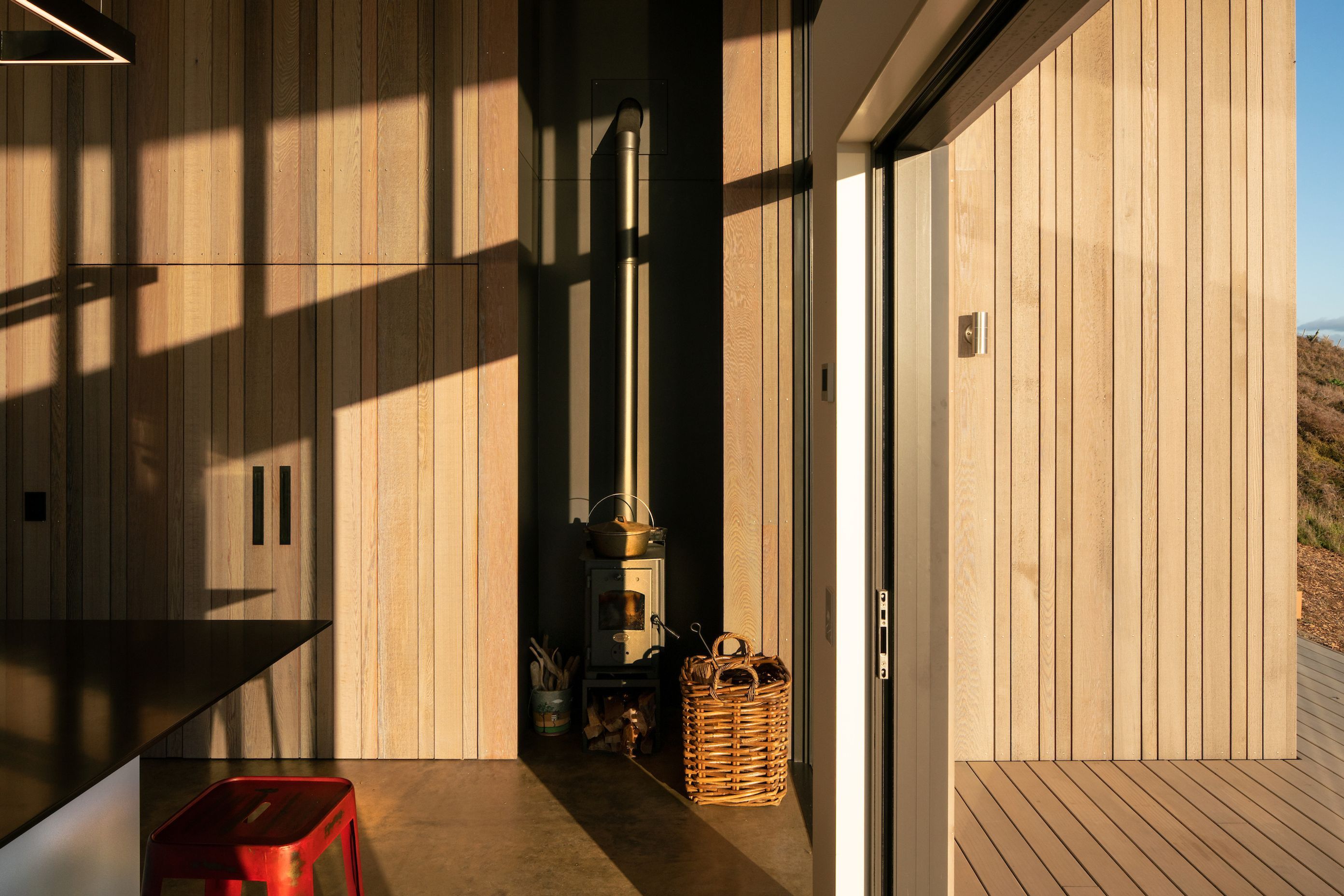 Cedar cladding extends from the exterior to the interior, creating a seamless aesthetic and indoor-outdoor flow.