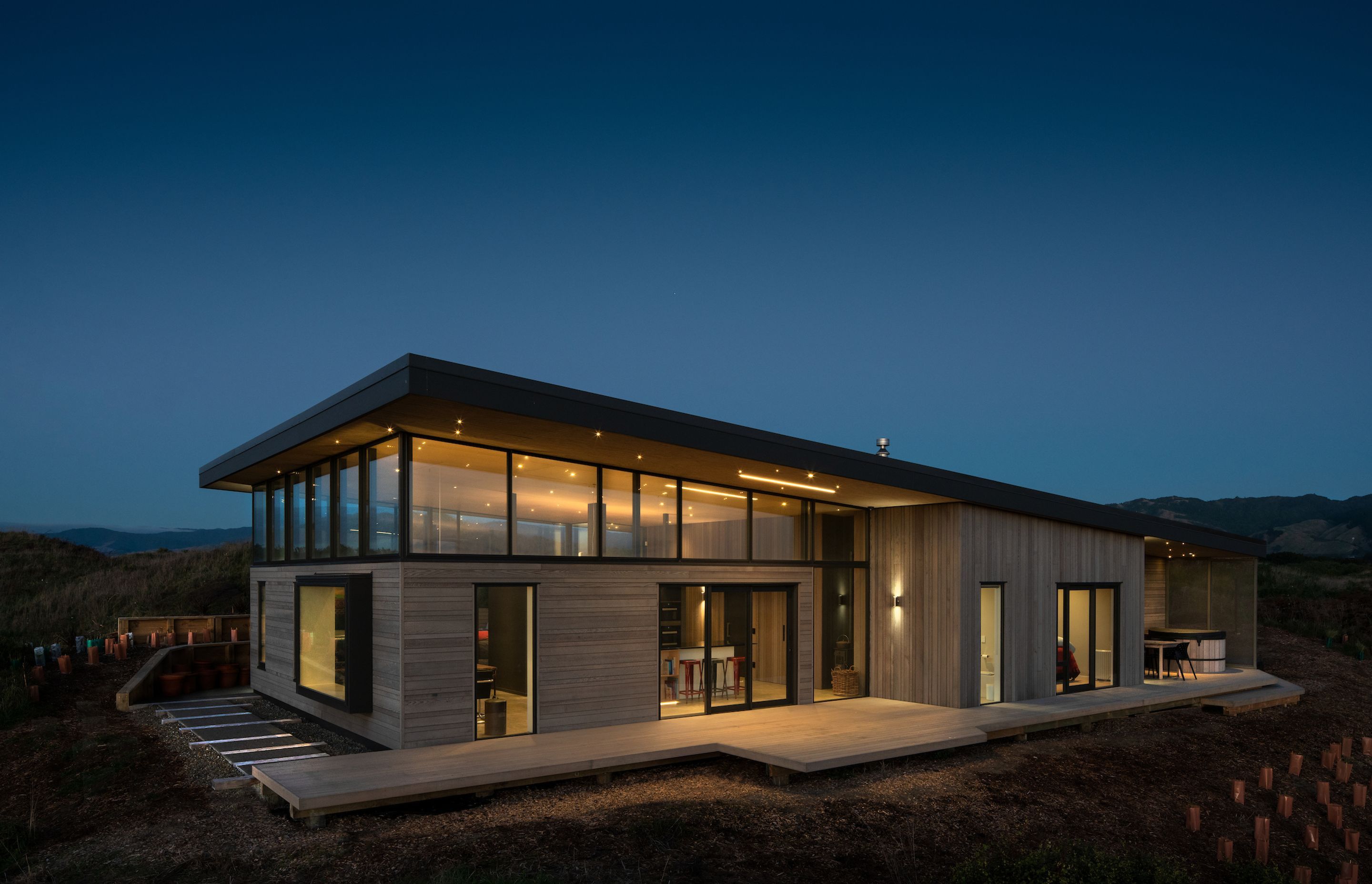 While the monopitched cantilevered roof helps mitigate solar gain, clerestory windows admit natural light and allow sight lines from within the building of the nearby Tararua Ranges.