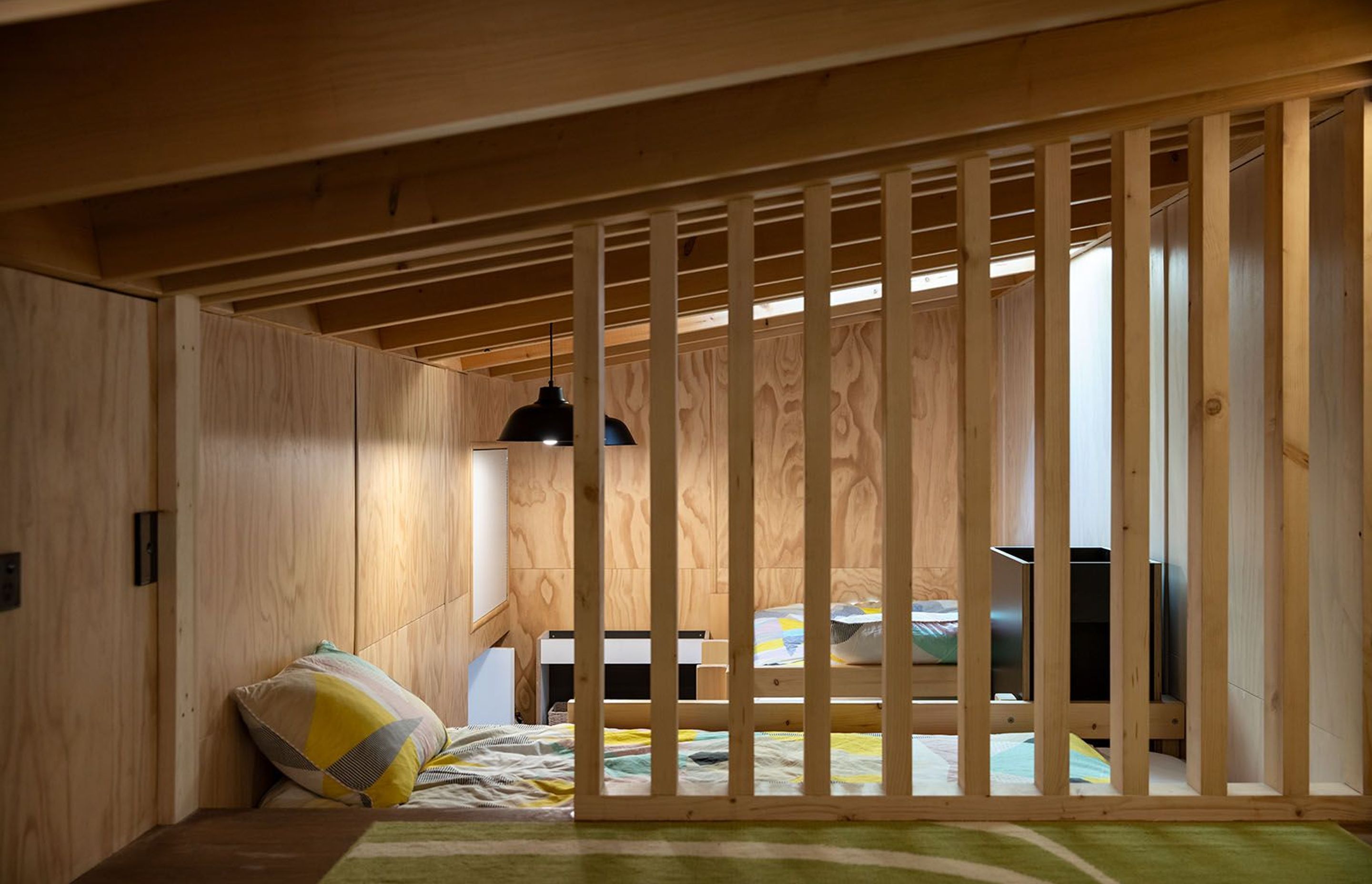 The top-lit loft bedroom doubles as a play space for the owners' young children.