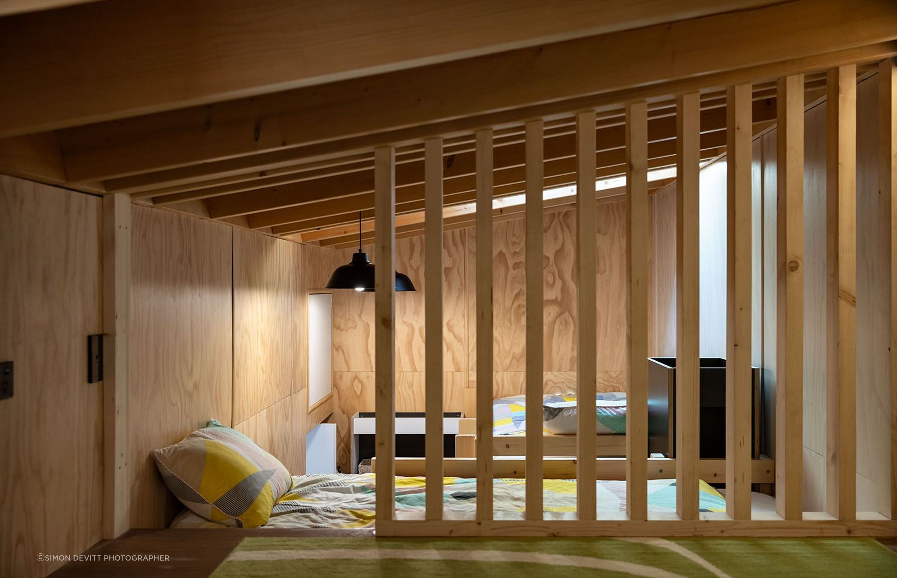The top-lit loft bedroom doubles as a play space for the owners' young children.
