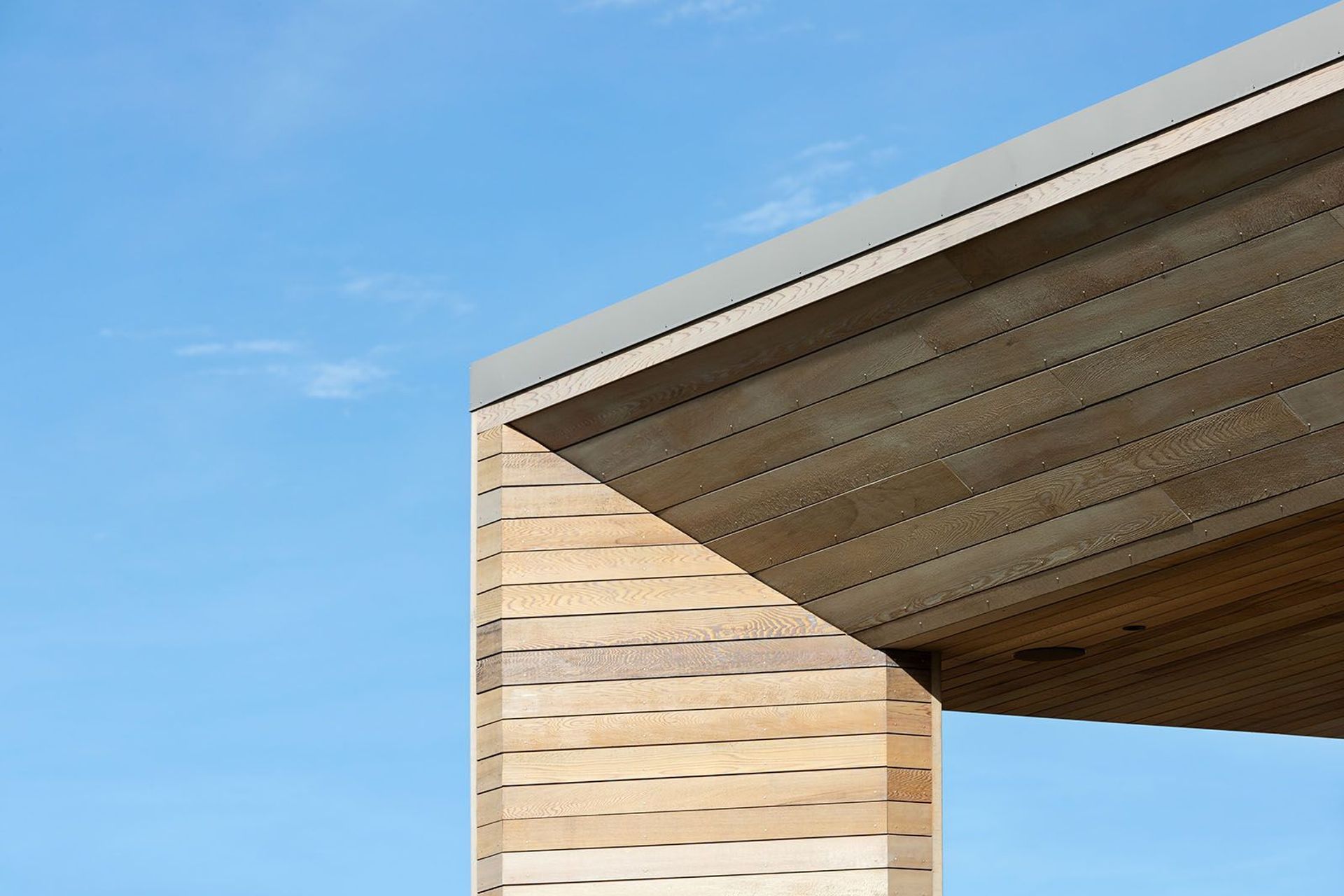 A close-up view of the cedar cladding and sofft on the balcony, which angles inwards to create a distinctive faceted effect.