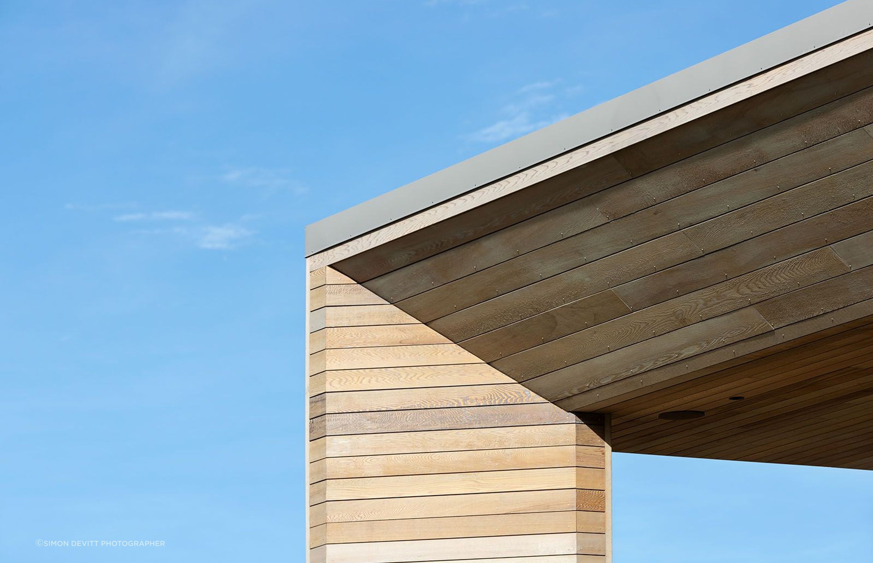 A close-up view of the cedar cladding and sofft on the balcony, which angles inwards to create a distinctive faceted effect.