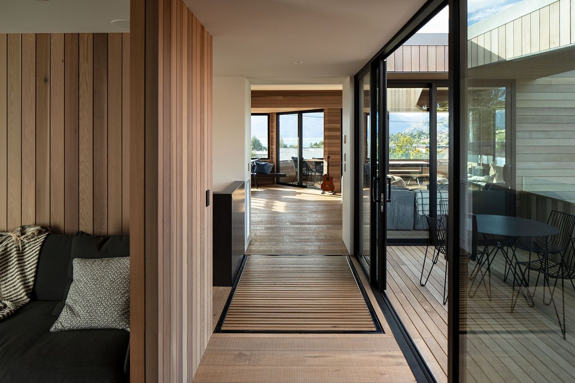 On the upper storey, the corridor leads to the media room and stairwell (left), morning deck (right) and the open-plan living area (centre).