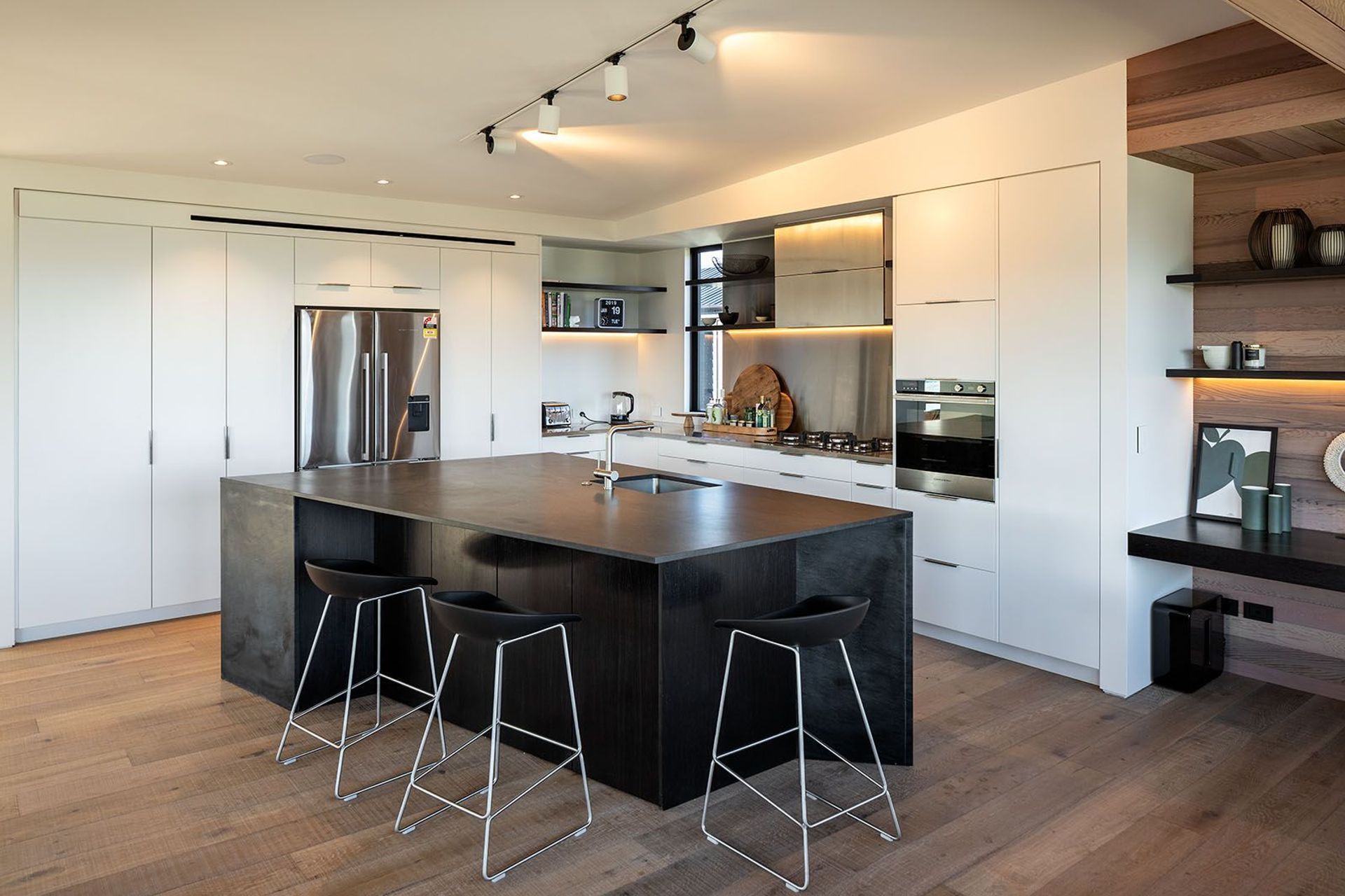 A large black island in the kitchen is a sculptural form that mimics the shape of the building.