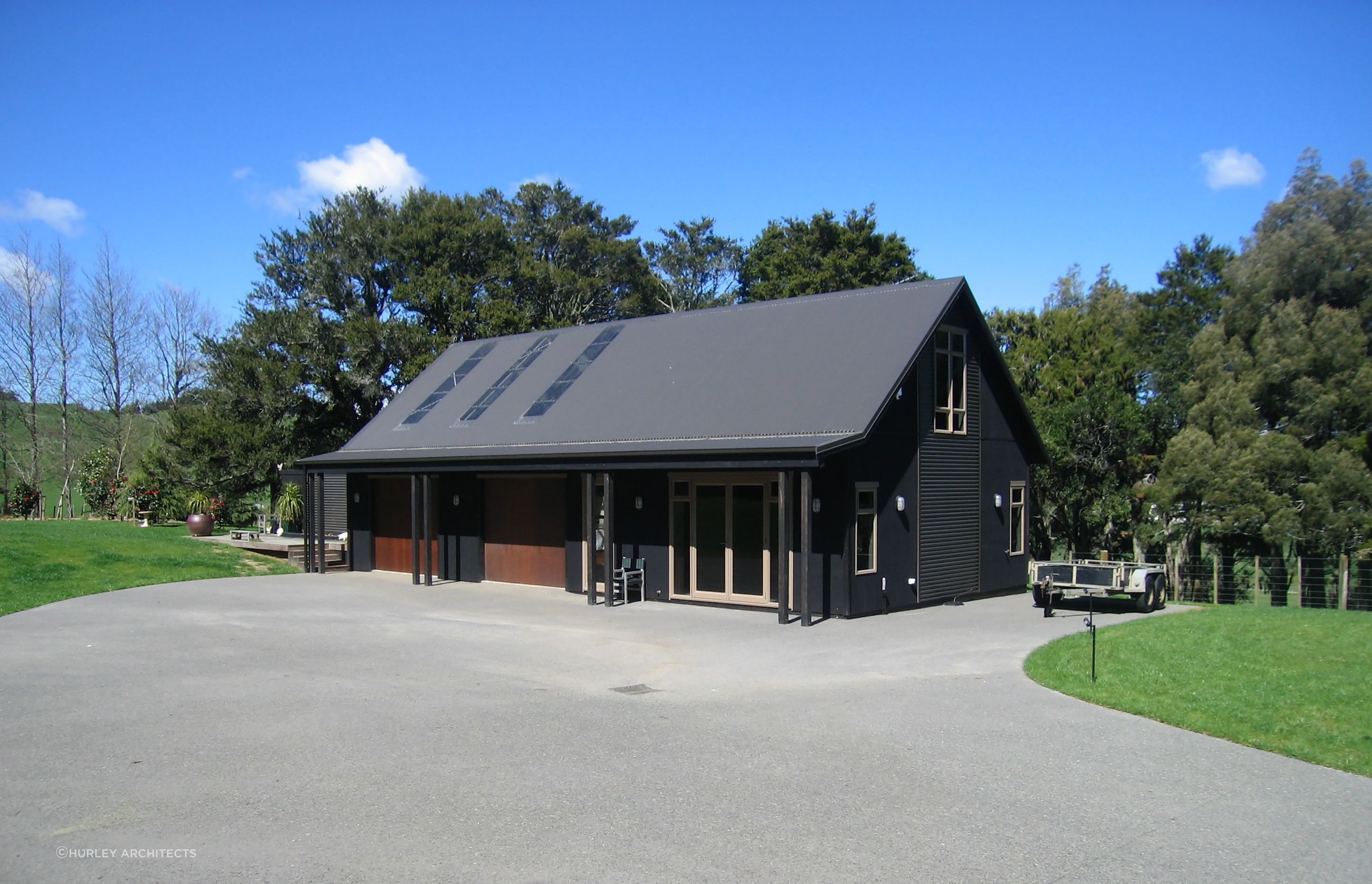 The separate barn matches the colours of the main house, using more utilitarian materials. It includes a self contained studio flat.