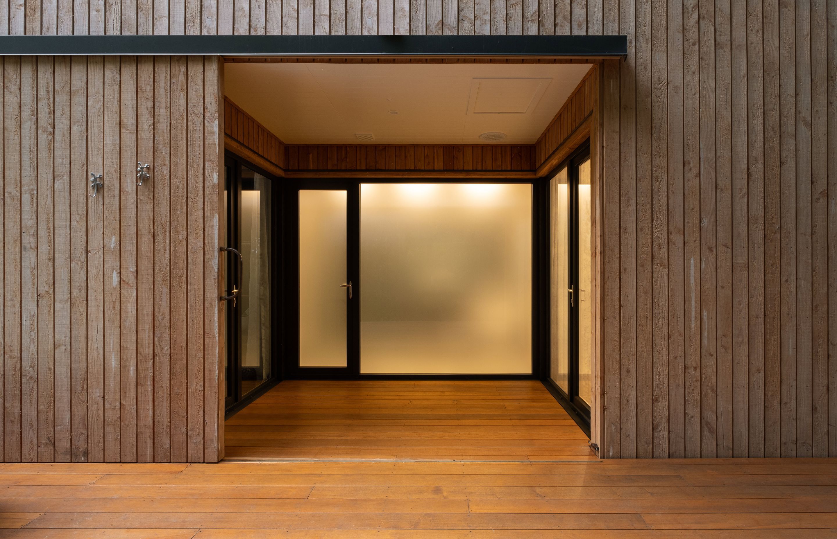 The entry space connects the three 'cells' that comprise the building and compels visitors to venture outside in order to move between the spaces.