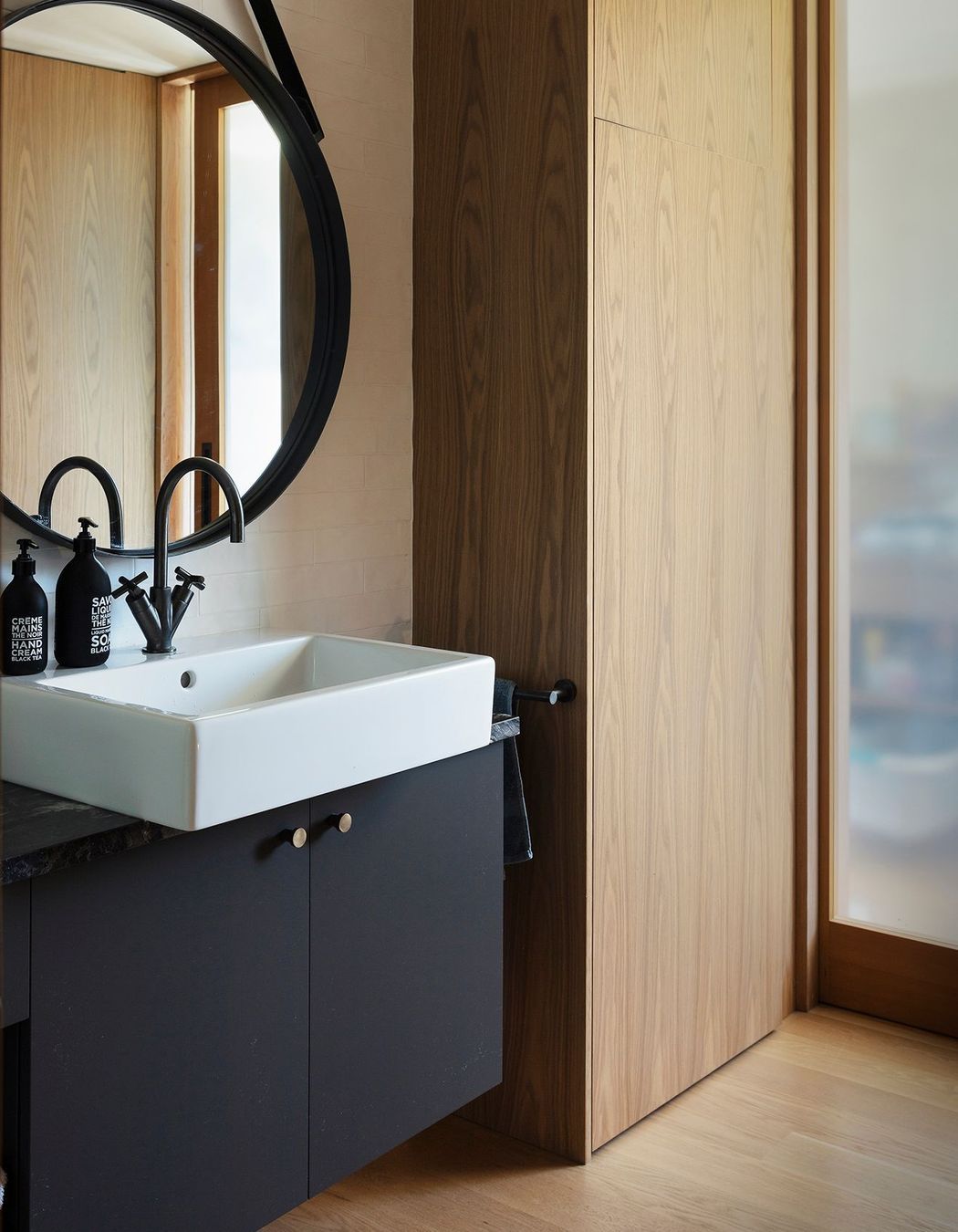 This elegant bathroom in monochromatic tones with timber.
