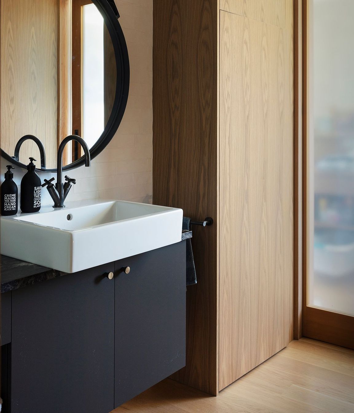 This elegant bathroom in monochromatic tones with timber.