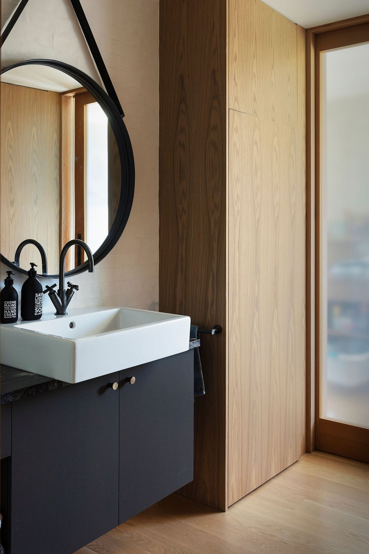 This elegant bathroom in monochromatic tones with timber.