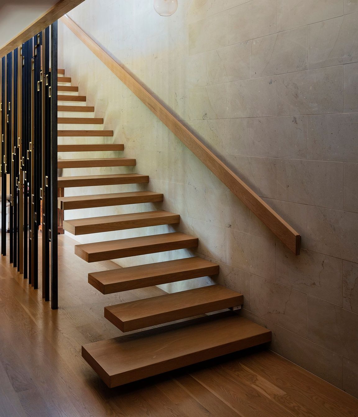 The staircase, with its brass and steel ‘sequin’ screen, sits at the heart of the home.