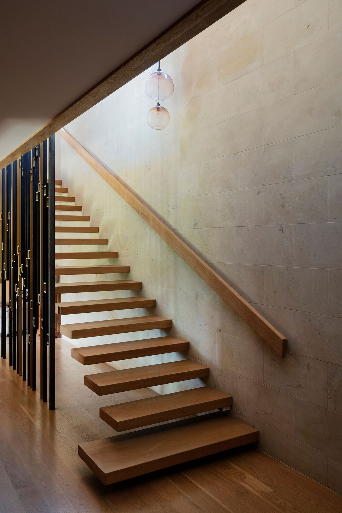 The staircase, with its brass and steel ‘sequin’ screen, sits at the heart of the home.