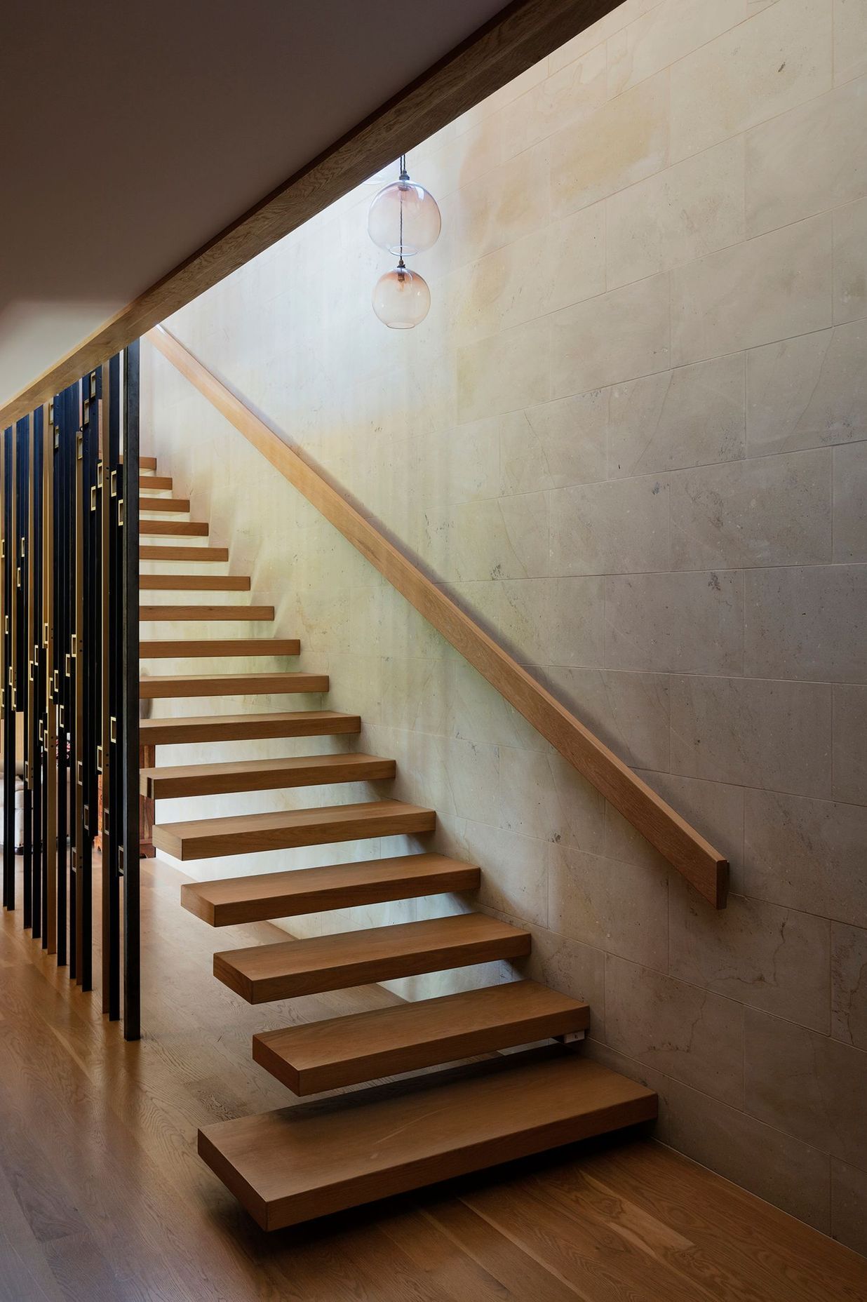 The staircase, with its brass and steel ‘sequin’ screen, sits at the heart of the home.
