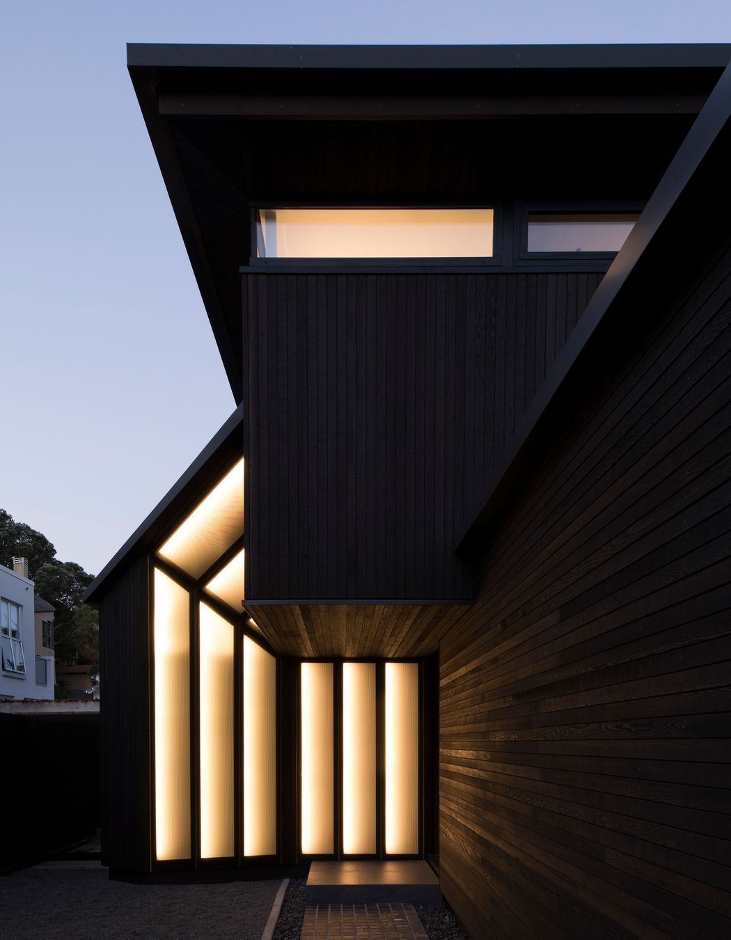 The entrance has perforated metal panels defined with gold piping when lit up at night.