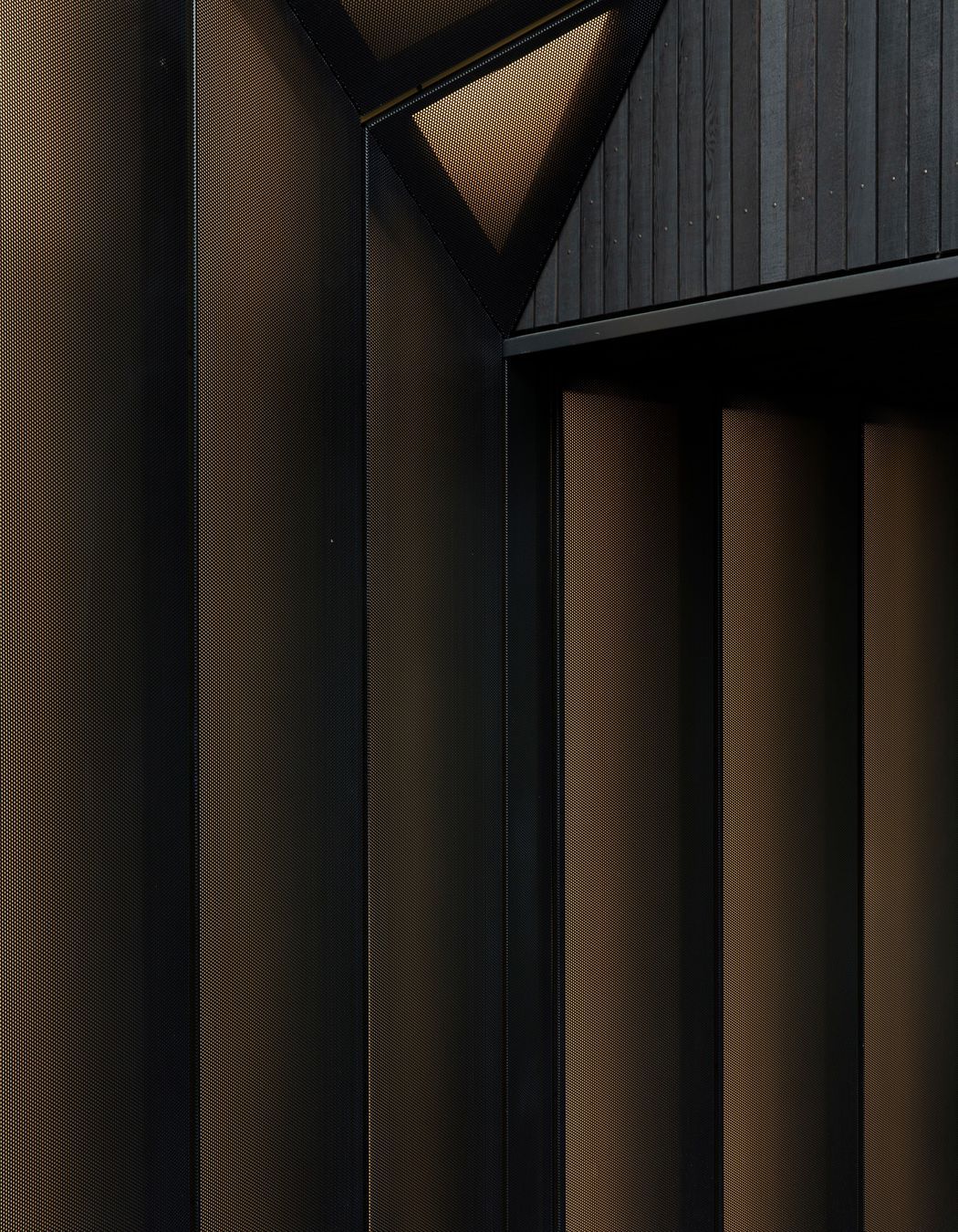 Perforated metal screens adopt the metaphor of a shirt cuff to define the entry. 