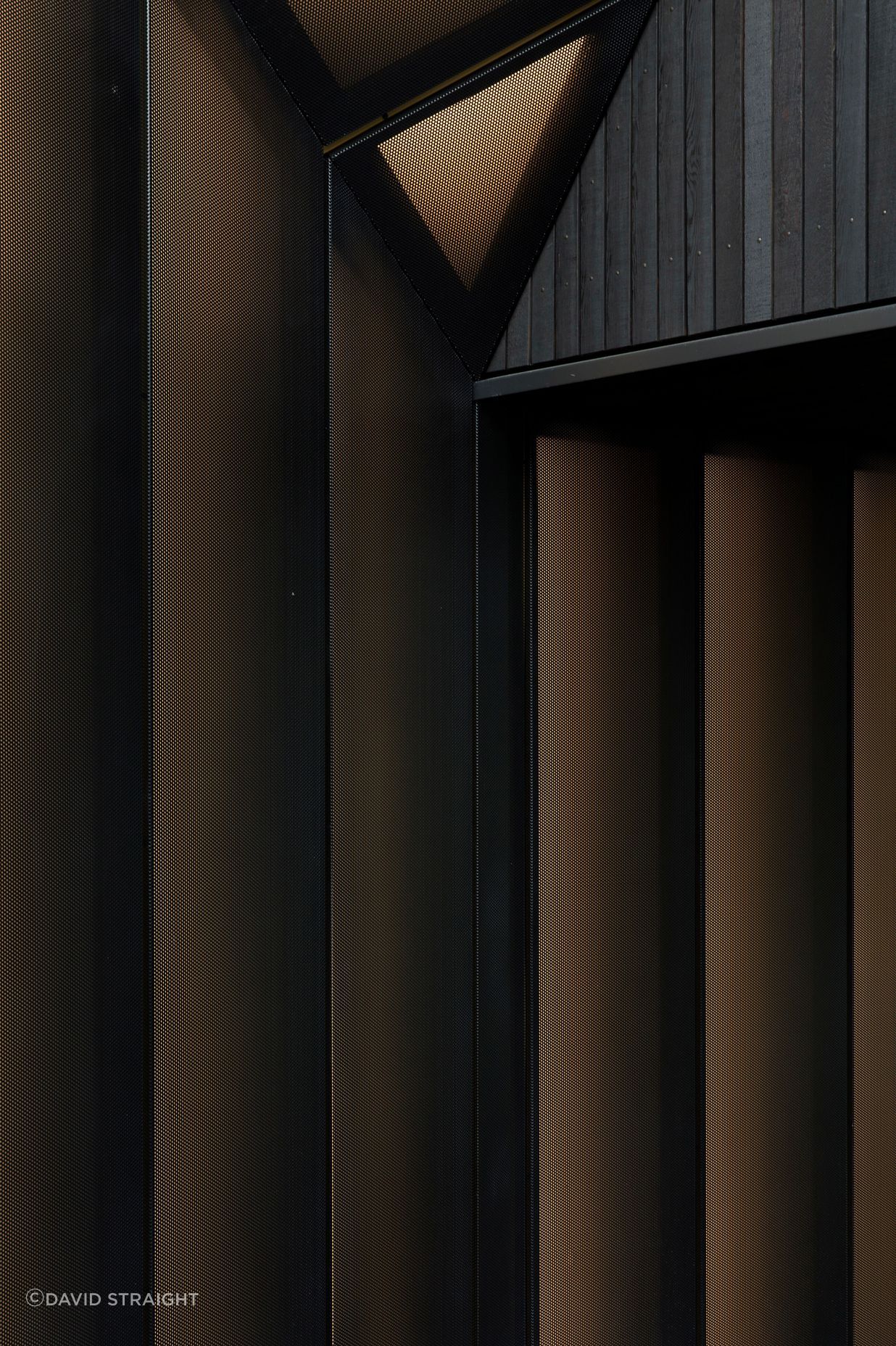 Perforated metal screens adopt the metaphor of a shirt cuff to define the entry. 